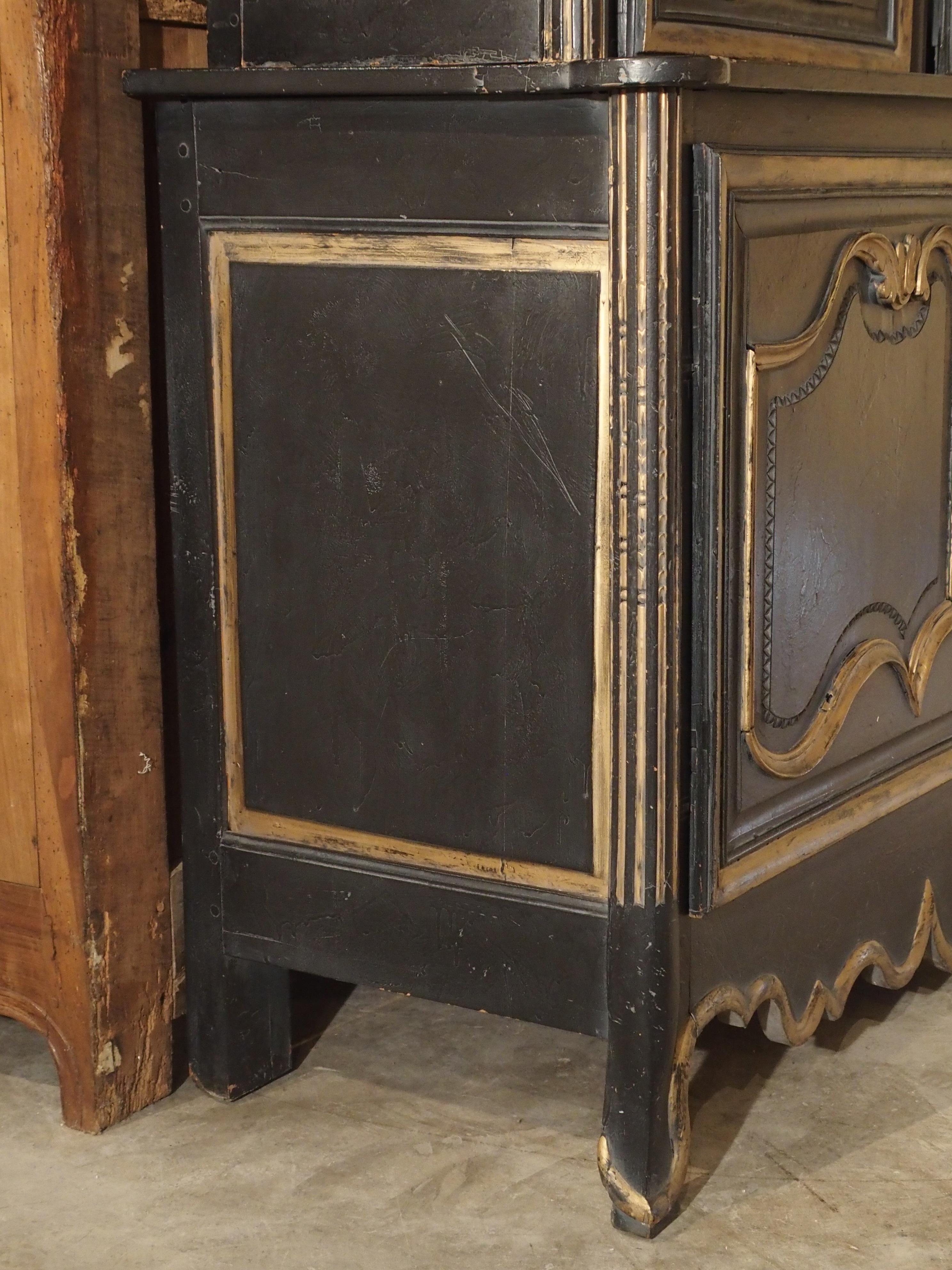 This unusual black and gold painted antique French deux corps dates to the early 20th century. Buffet 