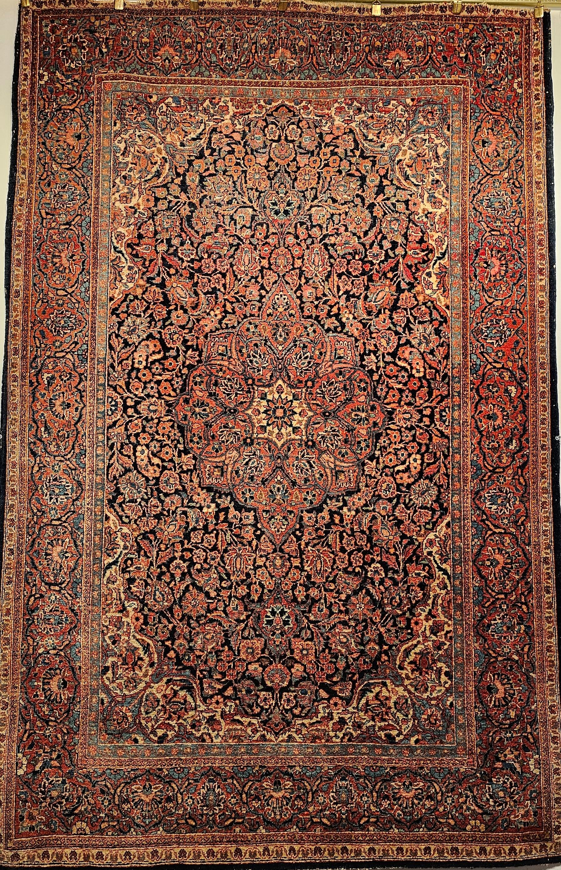 A beautiful Persian Kashan in a classic floral design from the early 1900s in Navy blue, French blue, ivory and rust red.   The beautiful French blue accent color is used extensively throughout the rug which makes it wonderful color combination. 
