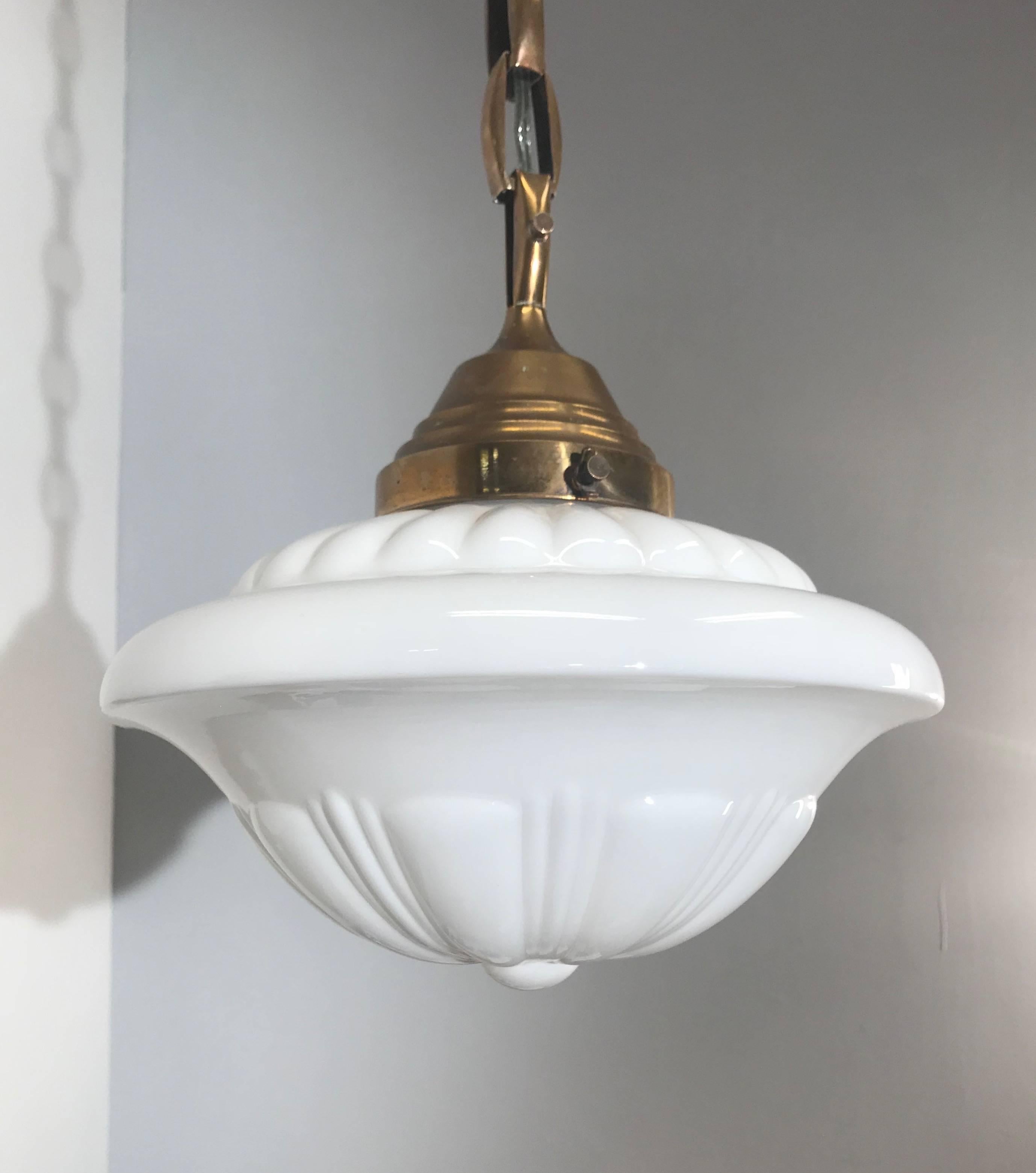 Highly stylish glass-art pendant light. 

This unique and stunning 1920s Art Deco pendant is of museum quality and condition. The combination of the beautifully designed, clean white shade and the excellent brass chain is a match made in heaven.