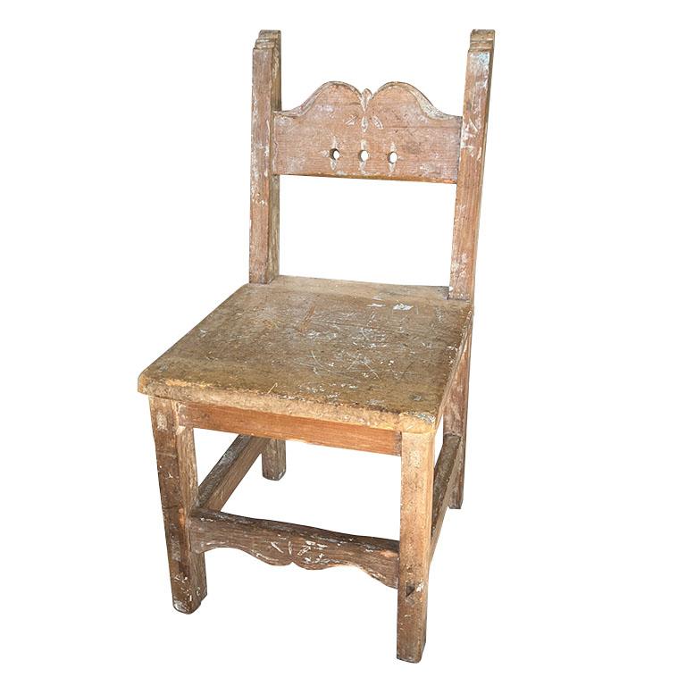 An early 1900s solid wood Spanish hand-carved wood child's chair. This piece is truly one of a kind. From the hand-carved details to the joints and superb construction, they simply do not make furniture like they used to. This petite chair is