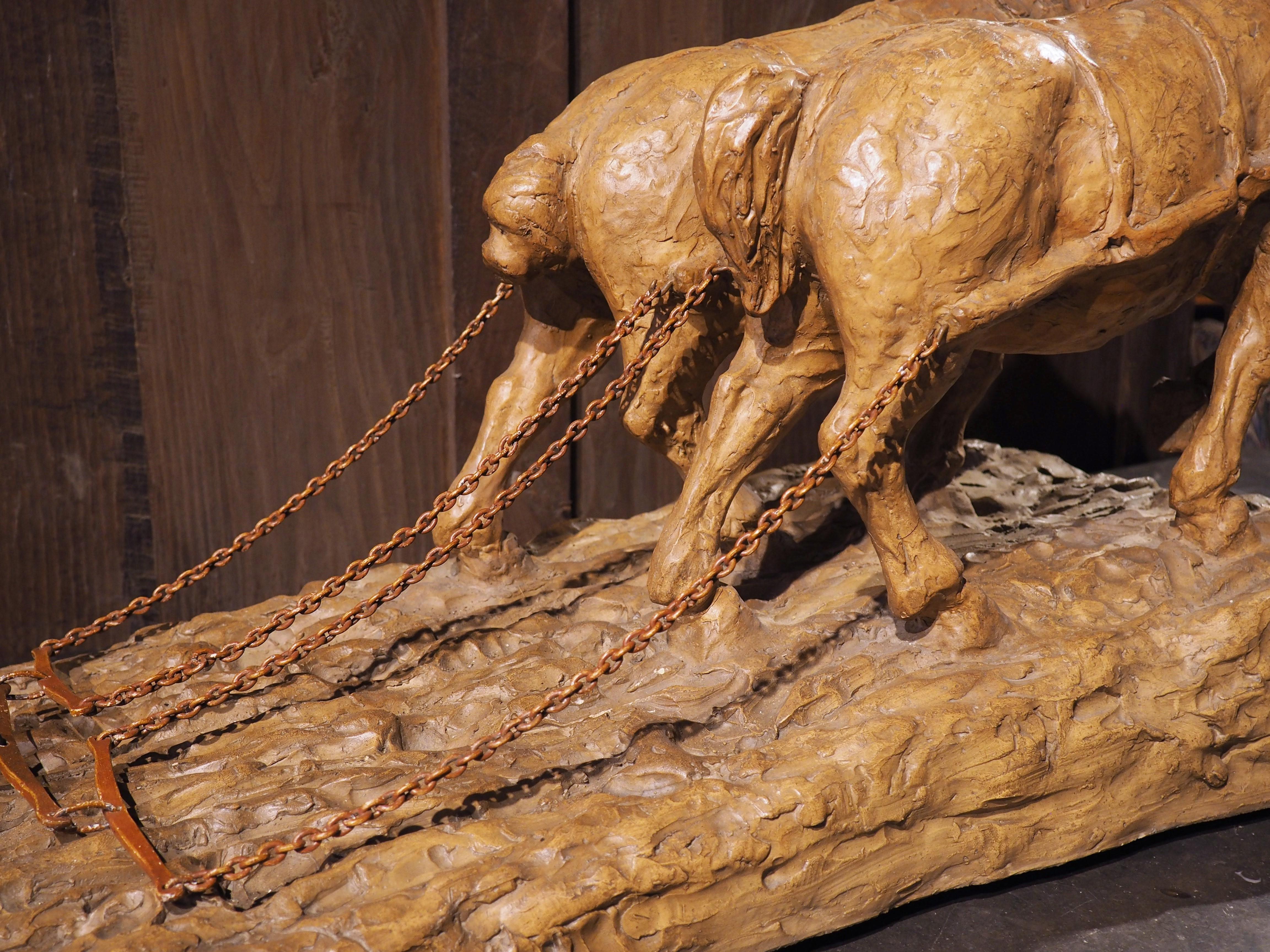 Signed “Geo Martel” on the left side of the ground, and measuring nearly 40 inches long, this terra cotta sculpture depicting horses plowing a field was created in France in the early 1900’s. The pair of yoked horses are wearing blinkers and pulling