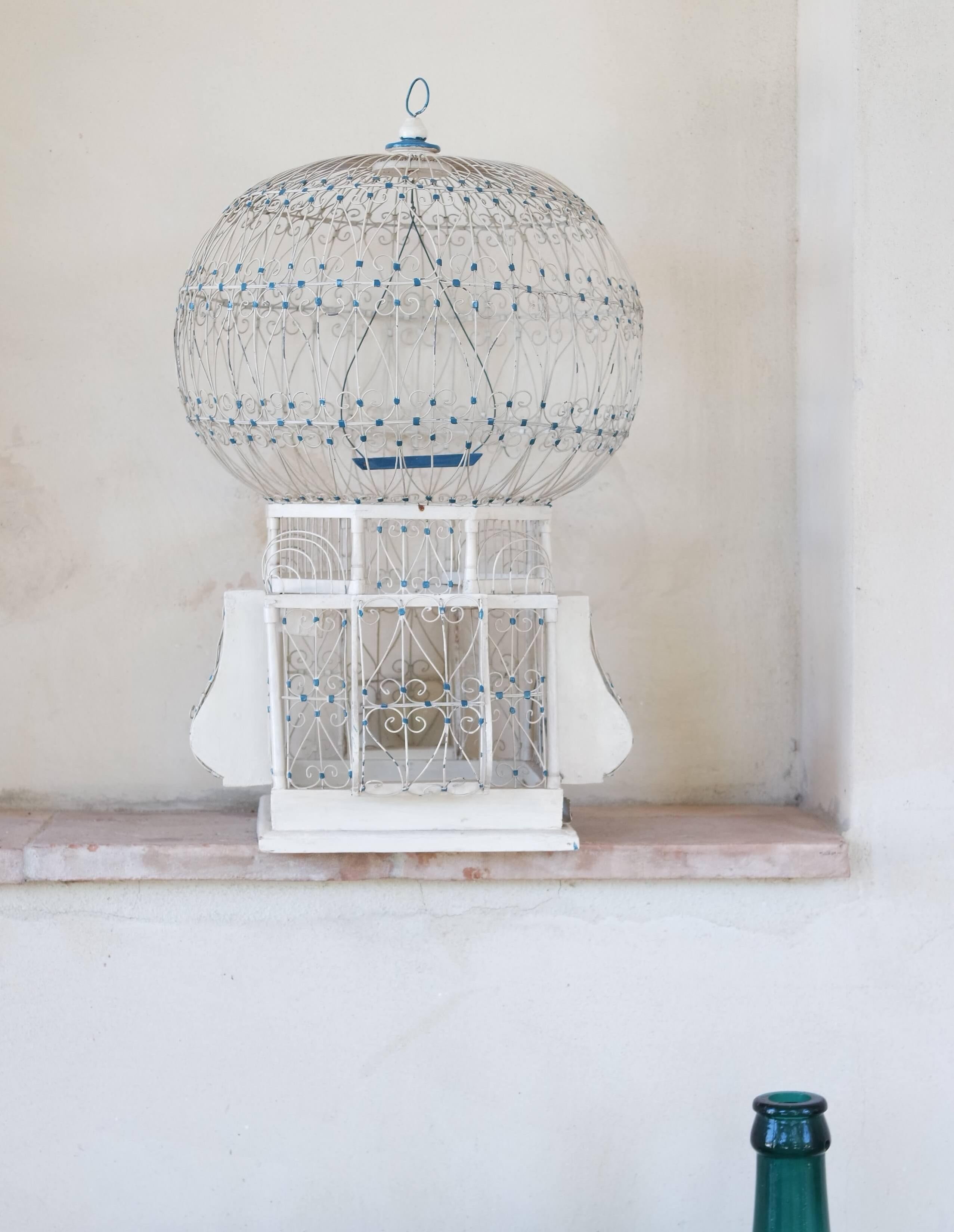 I have been on the lookout for the ideal vintage birdcage for some time and recently came across this wonderful specimen in Rome. It is made of wood and metal wire in cream and blue. It was made in the early 1900s and has an Asian design influence,