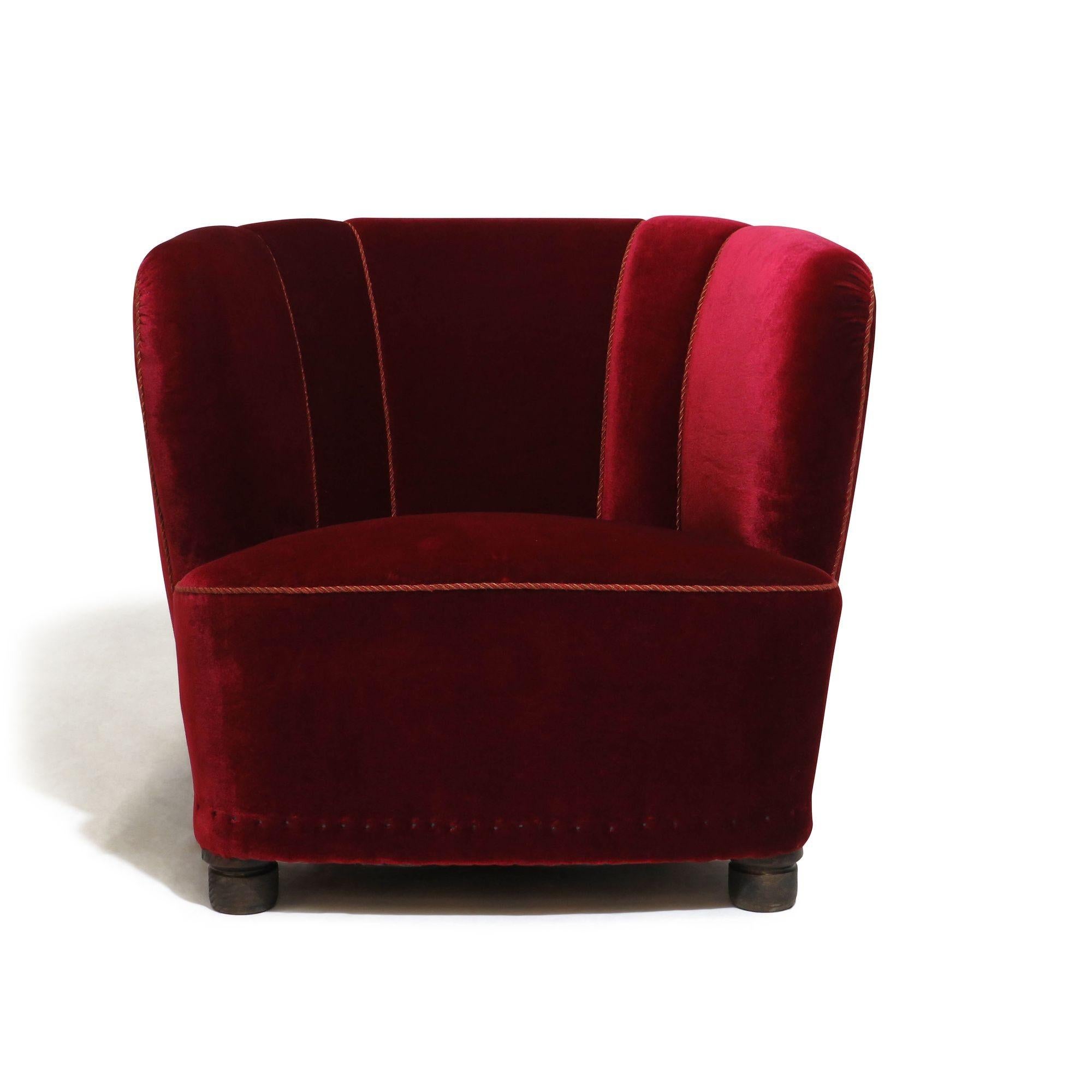Danish channel back lounge chairs, circa 1930 Denmark, handcrafted of a solid wood frame with eight-way hand-tied copper springs, horsehair and cotton, covered in the original red mohair fabric, raised on stained beech legs. The chairs can be used