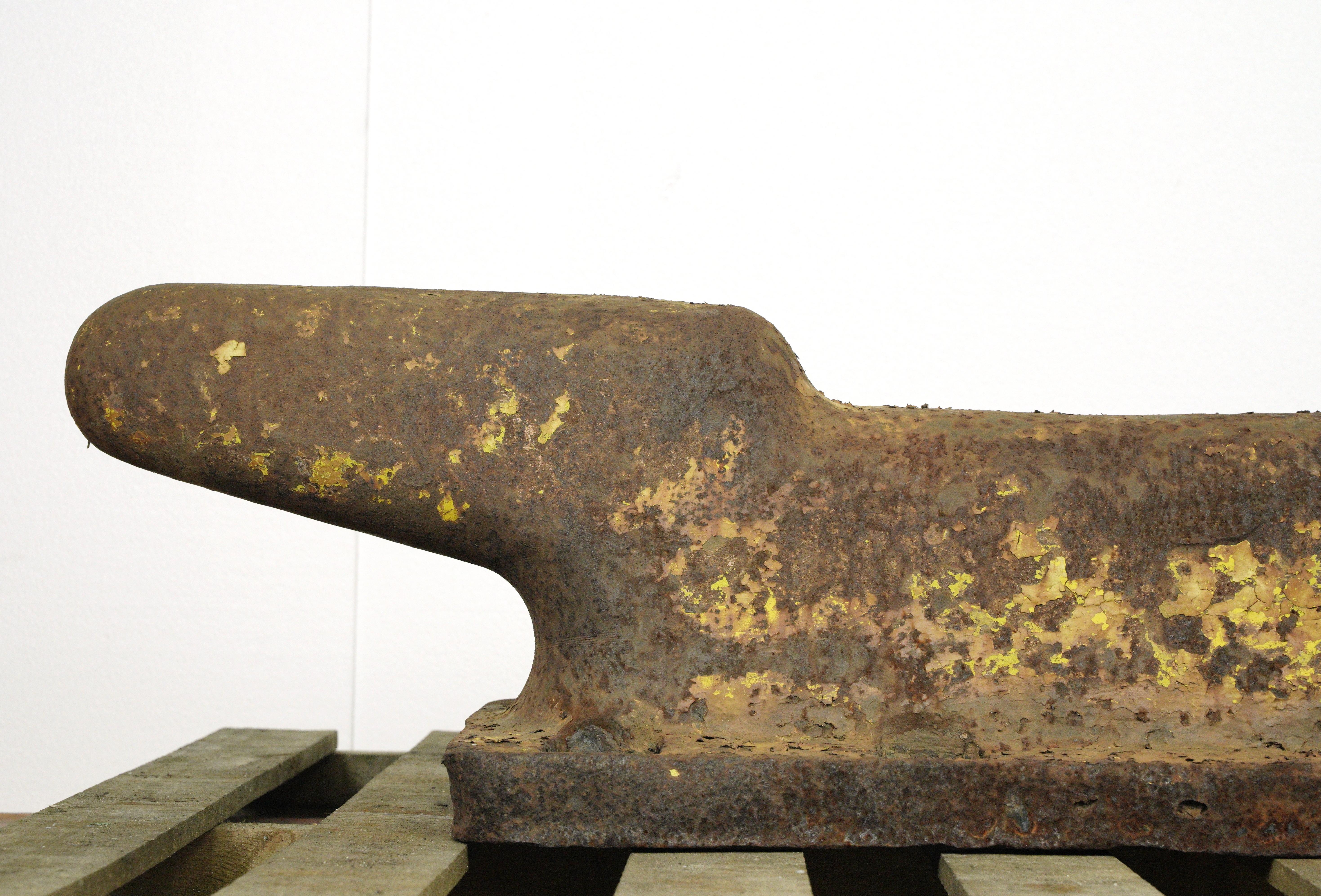 While exhibiting signs of weathering, including rust and a chipped corner, this early 1940s deck cleat is in good condition, showcasing the authentic charm of its maritime past. The rusted appearance contributes to the weathered aesthetic, telling a
