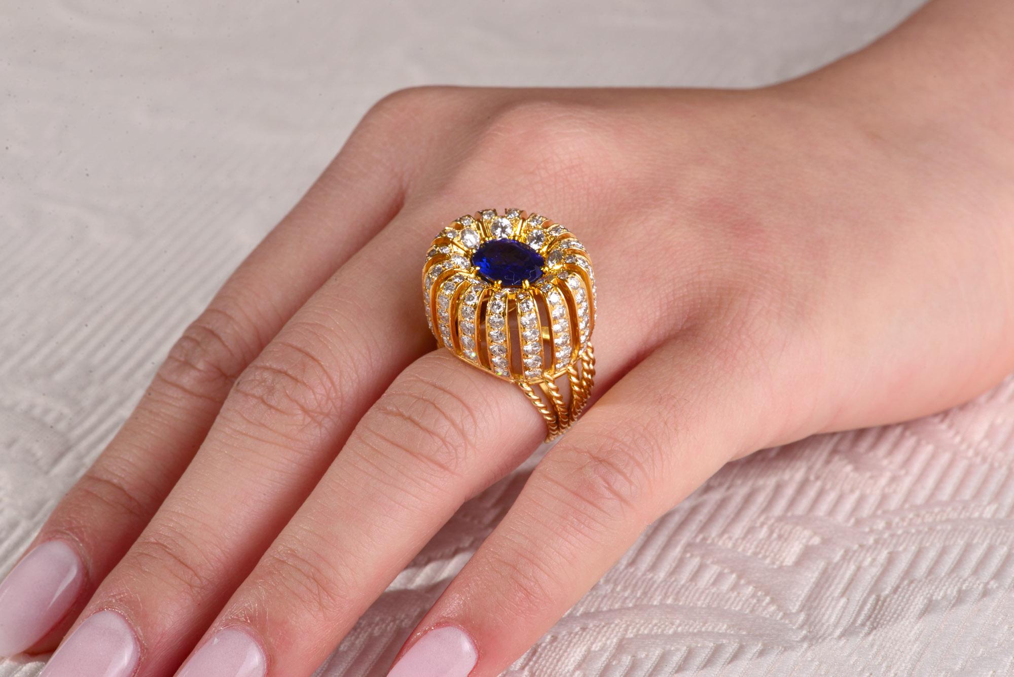  Extraordinary 18 carat Yellow Gold , Diamond and Sapphire handmade ring of the early 1950s s .This Bombe shaped ring is set to the centre with a Royal blue sapphire of an estimated weight of 2.10 cts with cascading sides in six sections each set