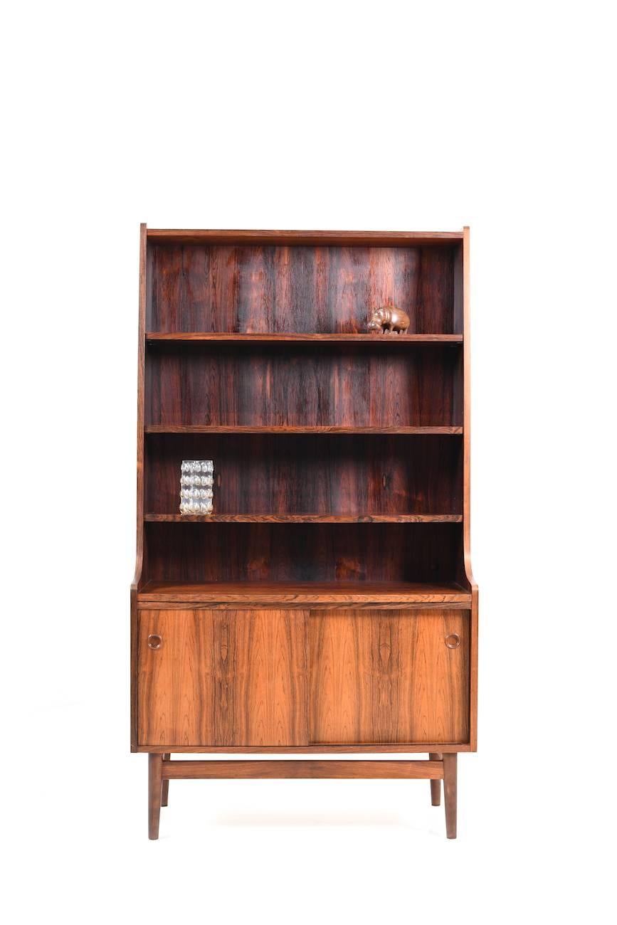 A Danish rosewood cabinet. Front with two doors and above with shelves. Made in Denmark, early 1960s.