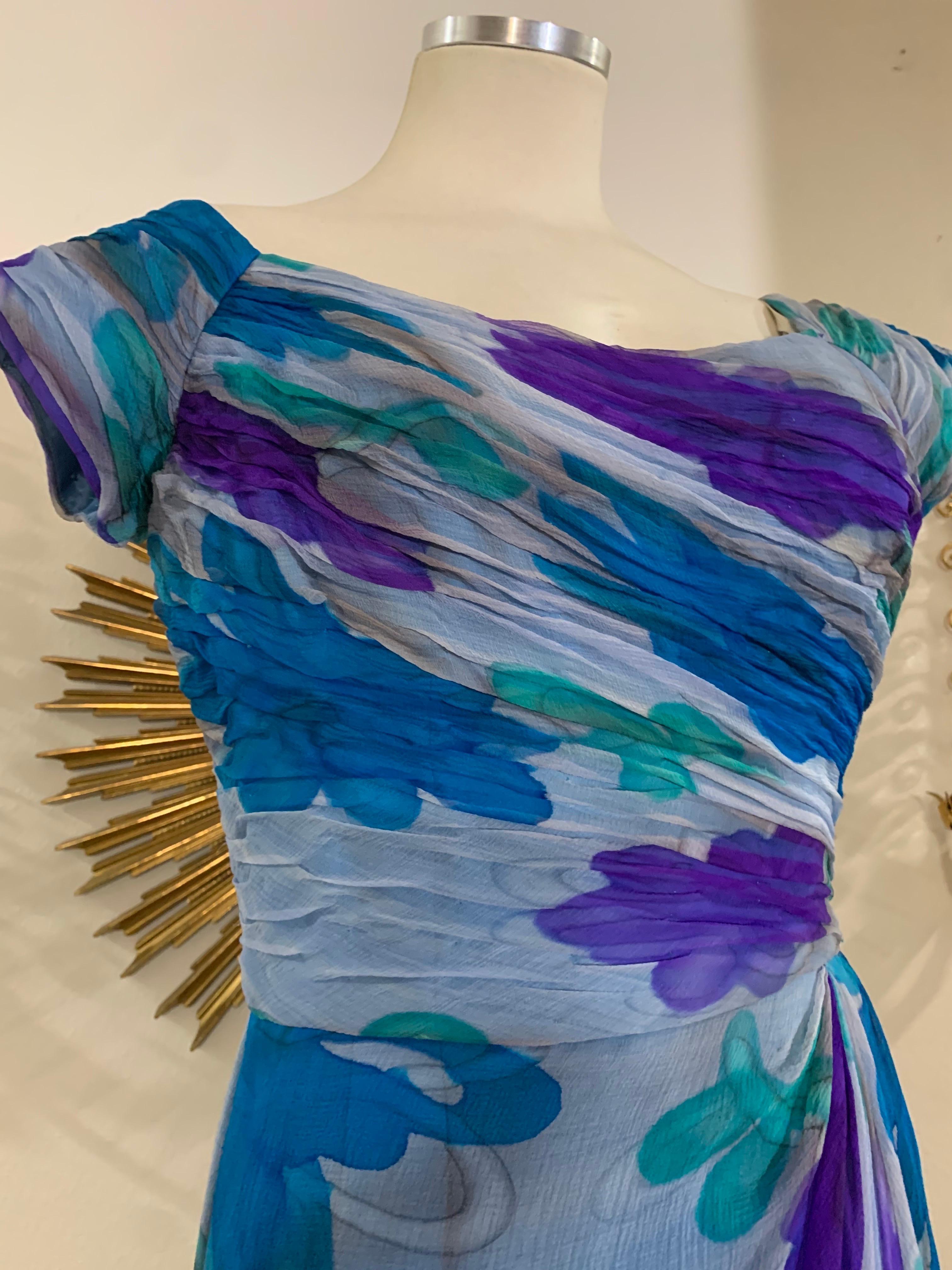 Early 1960s Gathered and Draped Chiffon Hand-Painted Silk Fitted Cocktail Dress: A fabulous Palm Royale period psychedelic floral cocktail dress with a chic gathered chiffon bodice and draped chiffon overskirt. Color palette is a vivid combination