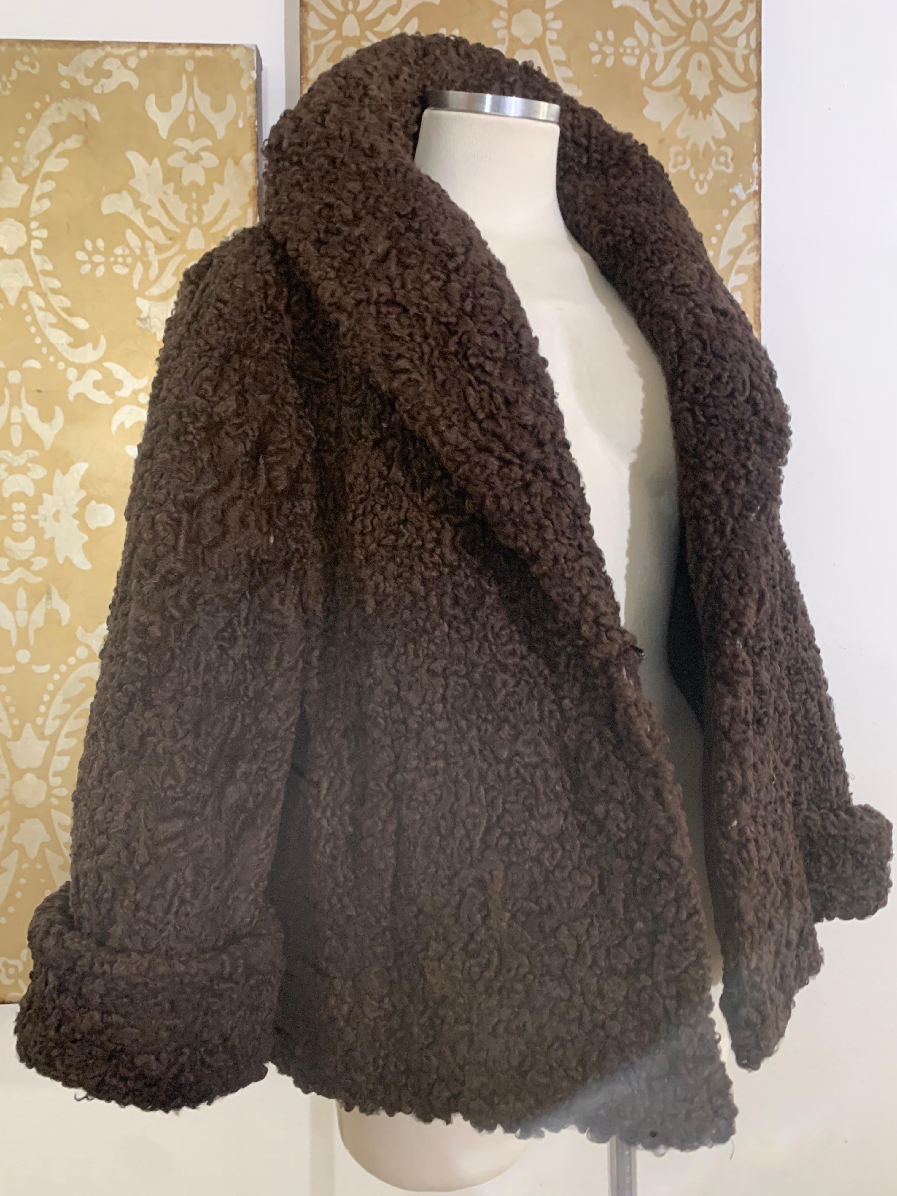 Early 1960s George Carmel Rich Chocolate Brown Persian Lamb Jacket with Shawl Collar, Deep Rolled Cuffs and Side Slit Pockets.  Hip length hemline with a slight flare. Fully lined with 2 hook and eye front closures. US size 6-8. Excellent condition. 