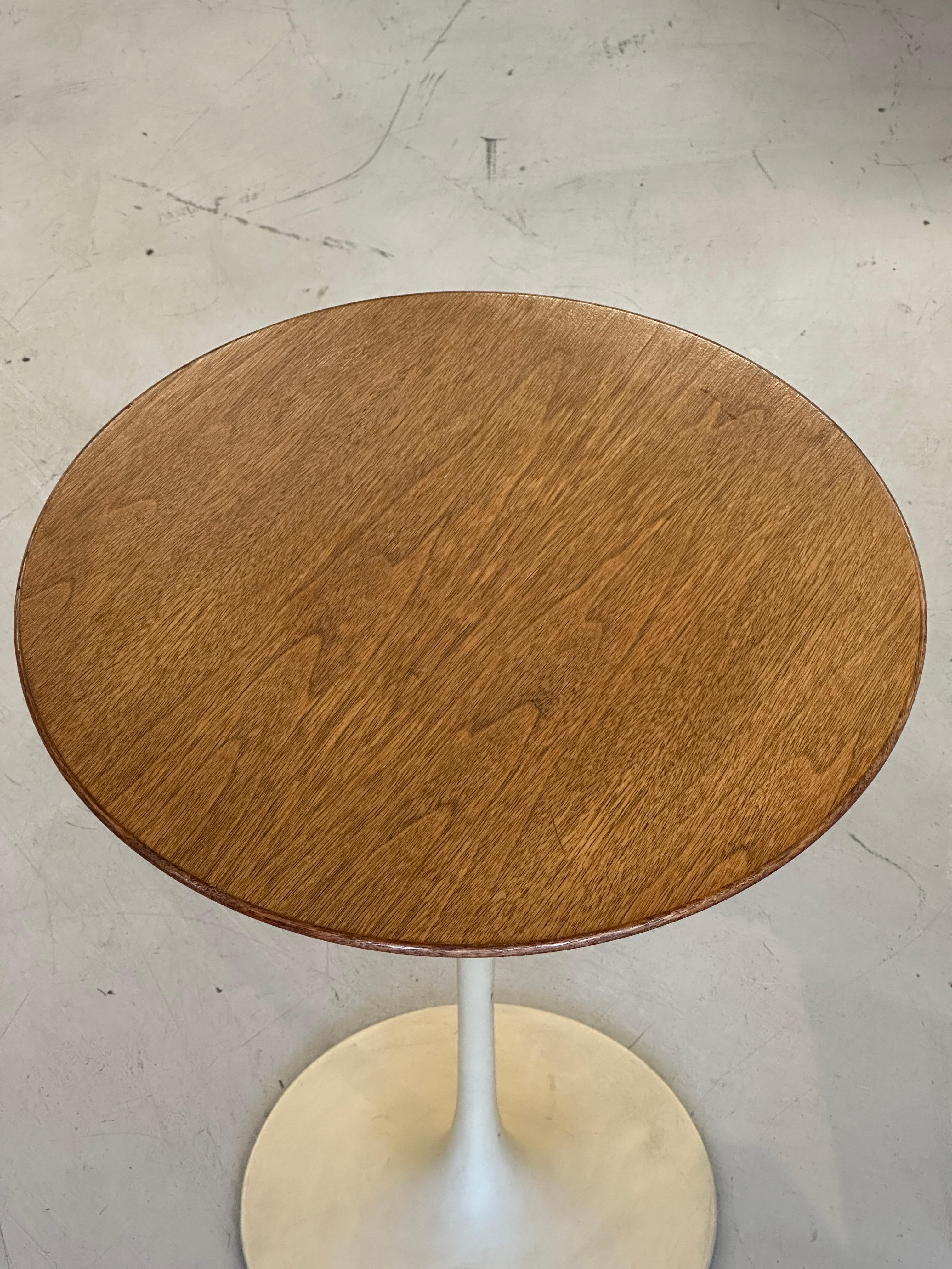 Lovely early Knoll Saarinen Tulip table with a walnut top. 16 inch diameter.  It bears the Knoll 320 Park Avenue label which dates it to the 1960’s. The table base looks to have been repainted at some point, it’s a beige color. The base has some