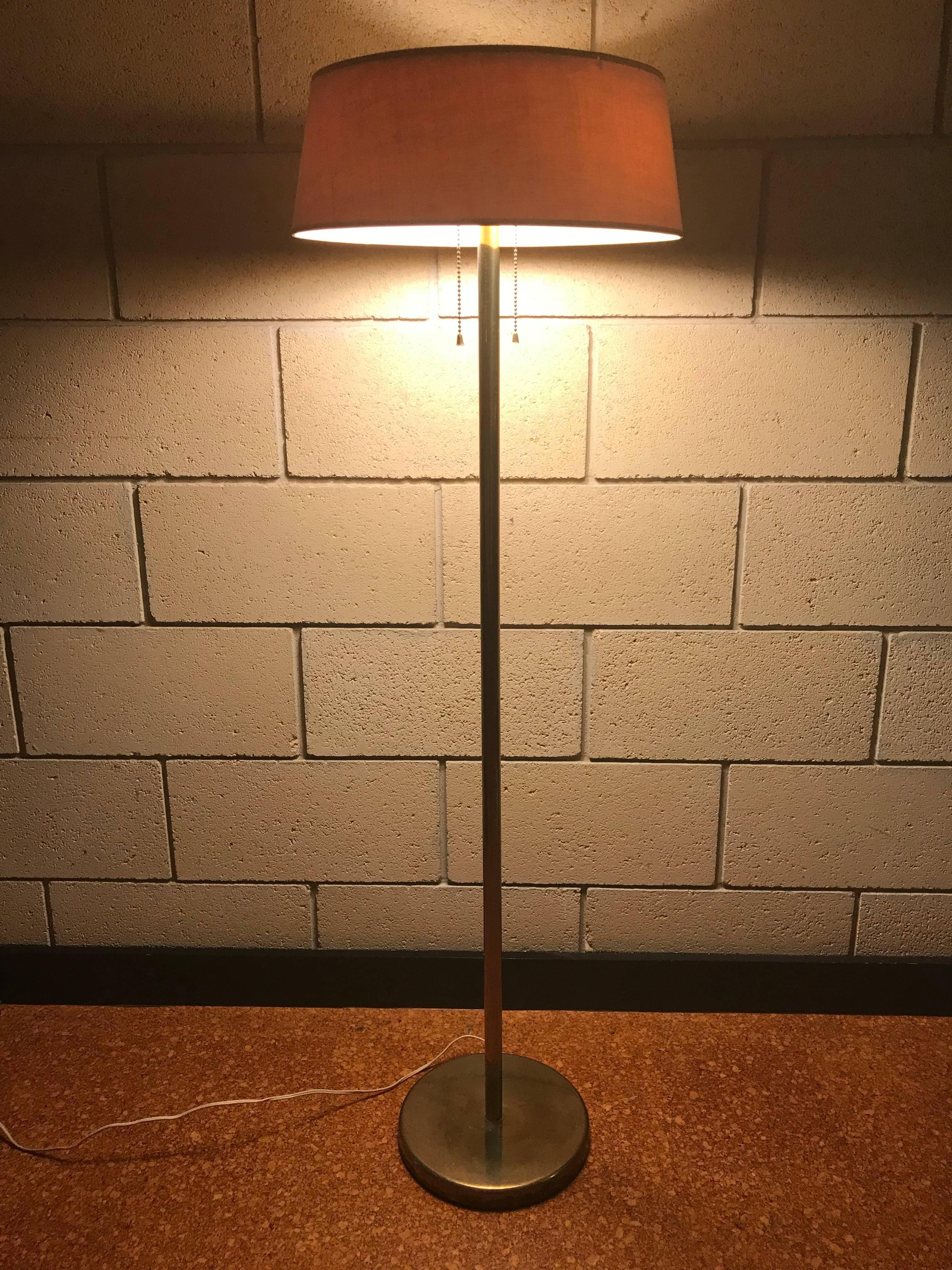 Nice original Minimalist floor lamp in brass by Walter Von Nessen for Nessen Studio. The shade, finial and top metal plate are original and only have very minor rubbing at the top rim of the shade. The brass 'stalk' of the lamp and the base have