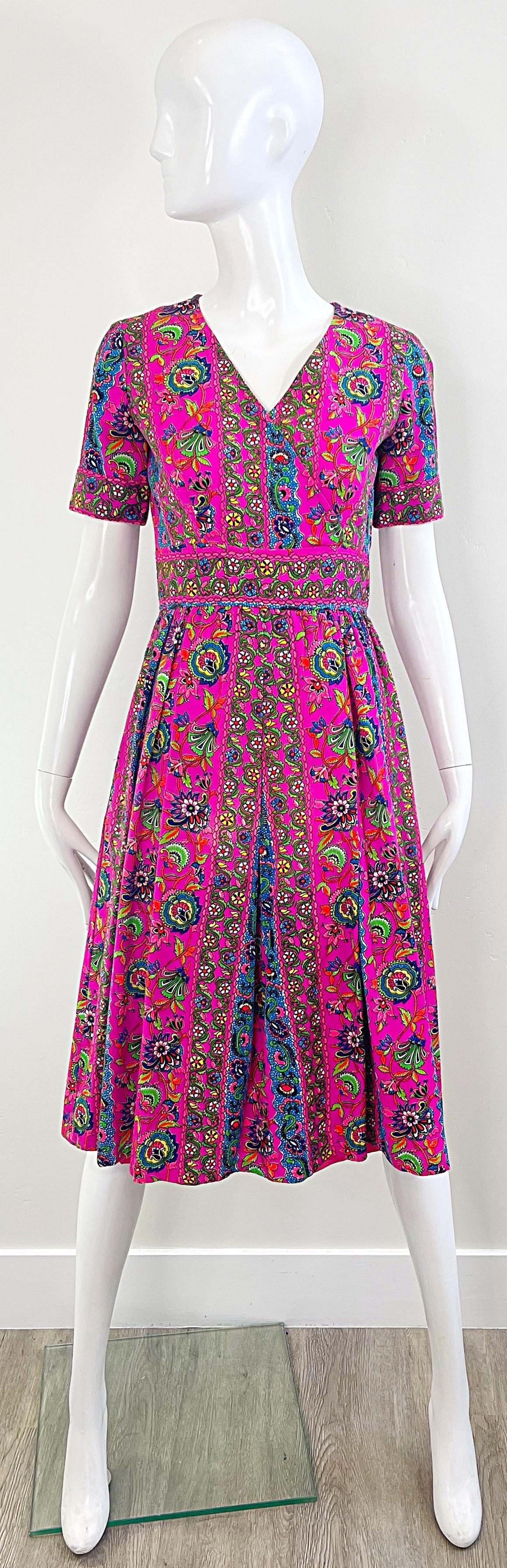 Chic début 70's hot neon pink colorful short sleeve A-Line dress ! Tissu léger en coton mélangé. Imprimés colorés en bleu vif, vert, orange et blanc sur l'ensemble de la pièce. Fermeture à glissière en métal sur toute la longueur du dos avec