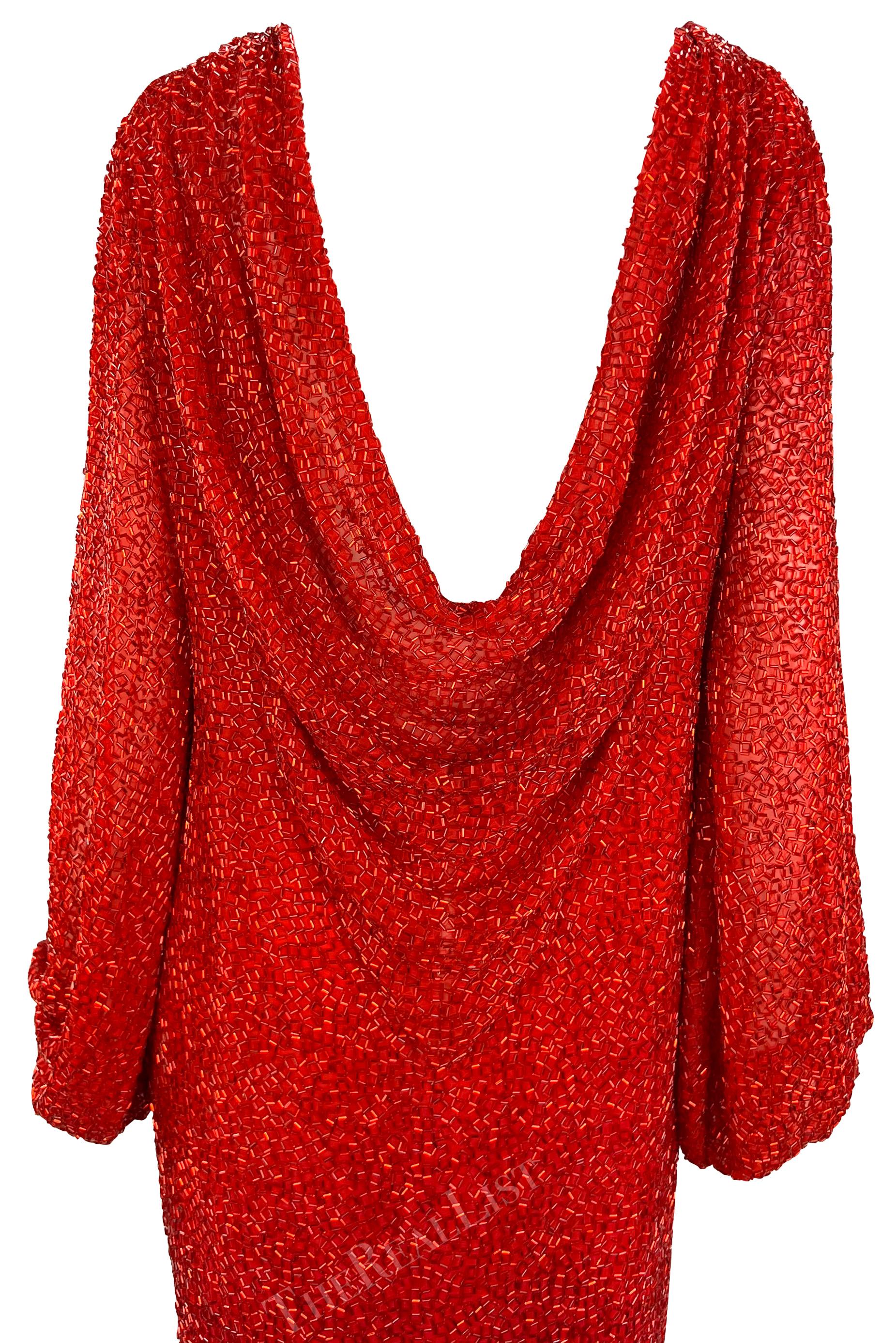 Aus den frühen 1980er Jahren stammt dieses unglaubliche rote, mit Perlen besetzte Bob Mackie-Kleid, das komplett mit glänzenden roten Röhrenperlen bedeckt ist. Dieses bodenlange Kleid hat Glockenärmel, einen hohen Schlitz an einer Seite und einen