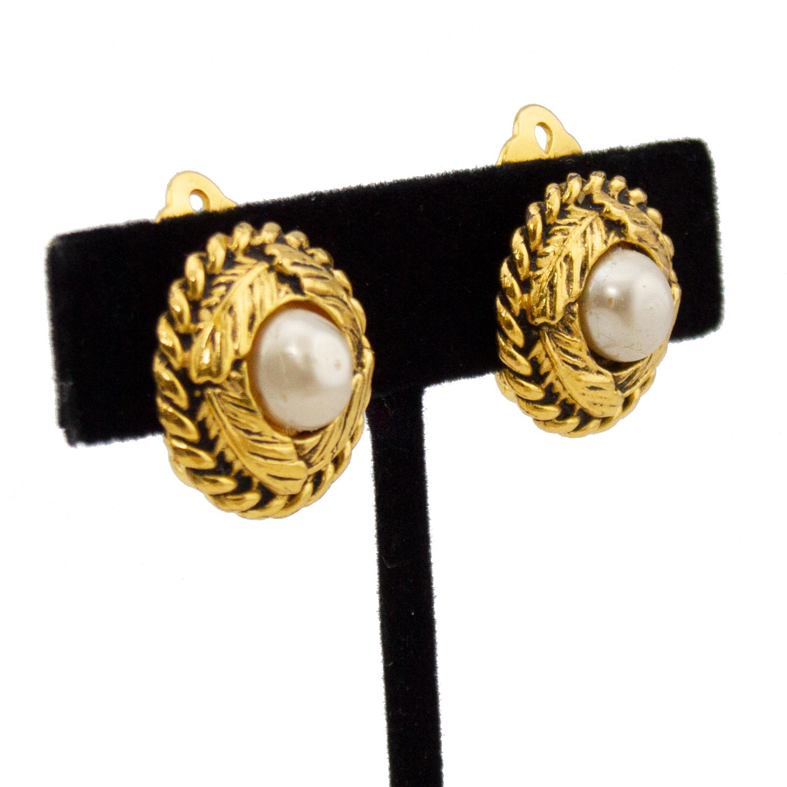 Classic and timeless gold tone metal Chanel clip on earrings. Twisted trim with banana leaves wrapped around a single pearl in the centre. Chanel logo plaque on back - this design pre-dates the year being stamped on the plaque. Excellent vintage