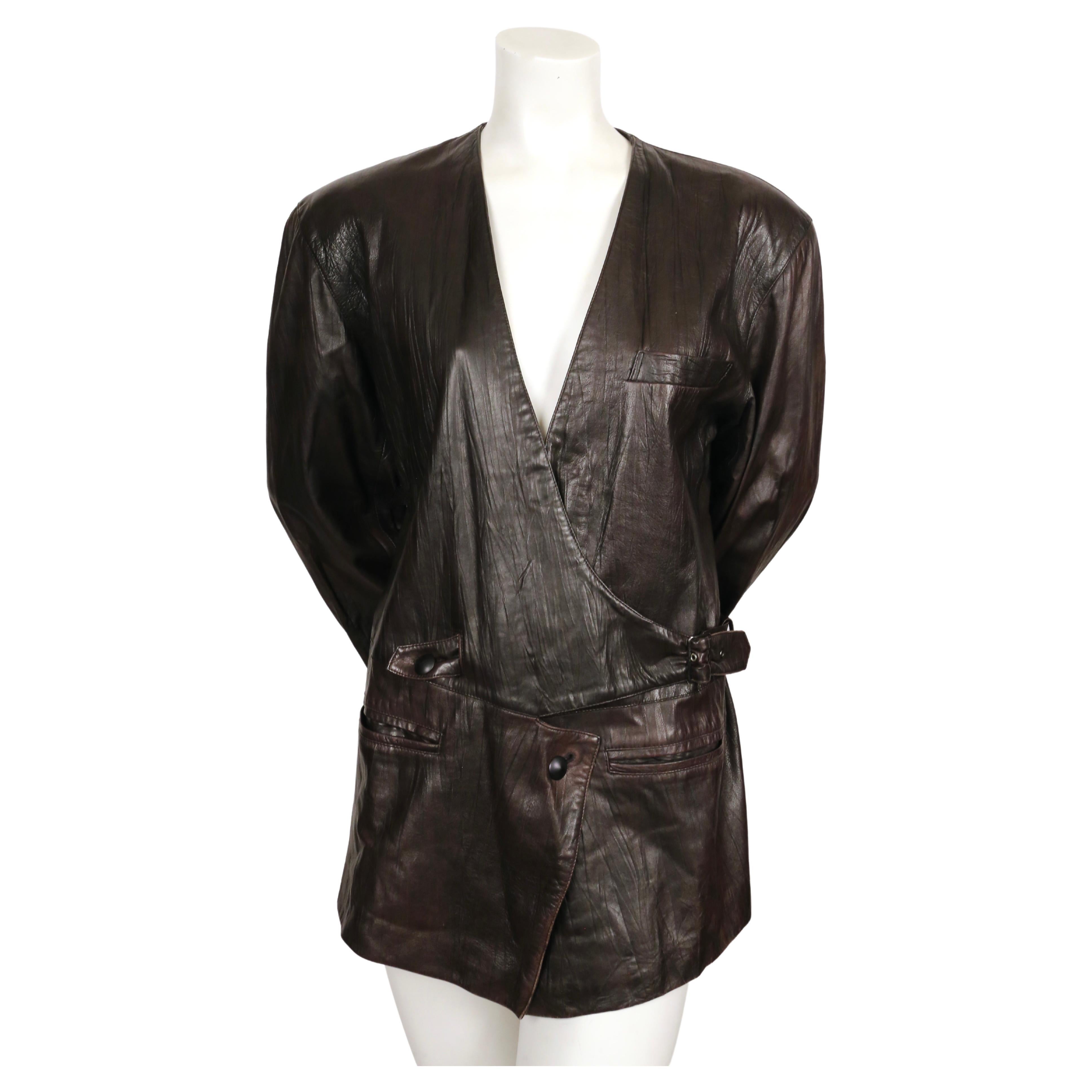 Unusual, dark-brown, collarless, textured leather jacket with oversized shoulders and buckle closure designed by Issey Miyake dating to the early 1980's. Japanese size 'S' which best fits a US 4-8. Approximate measurements: shoulder 18.5