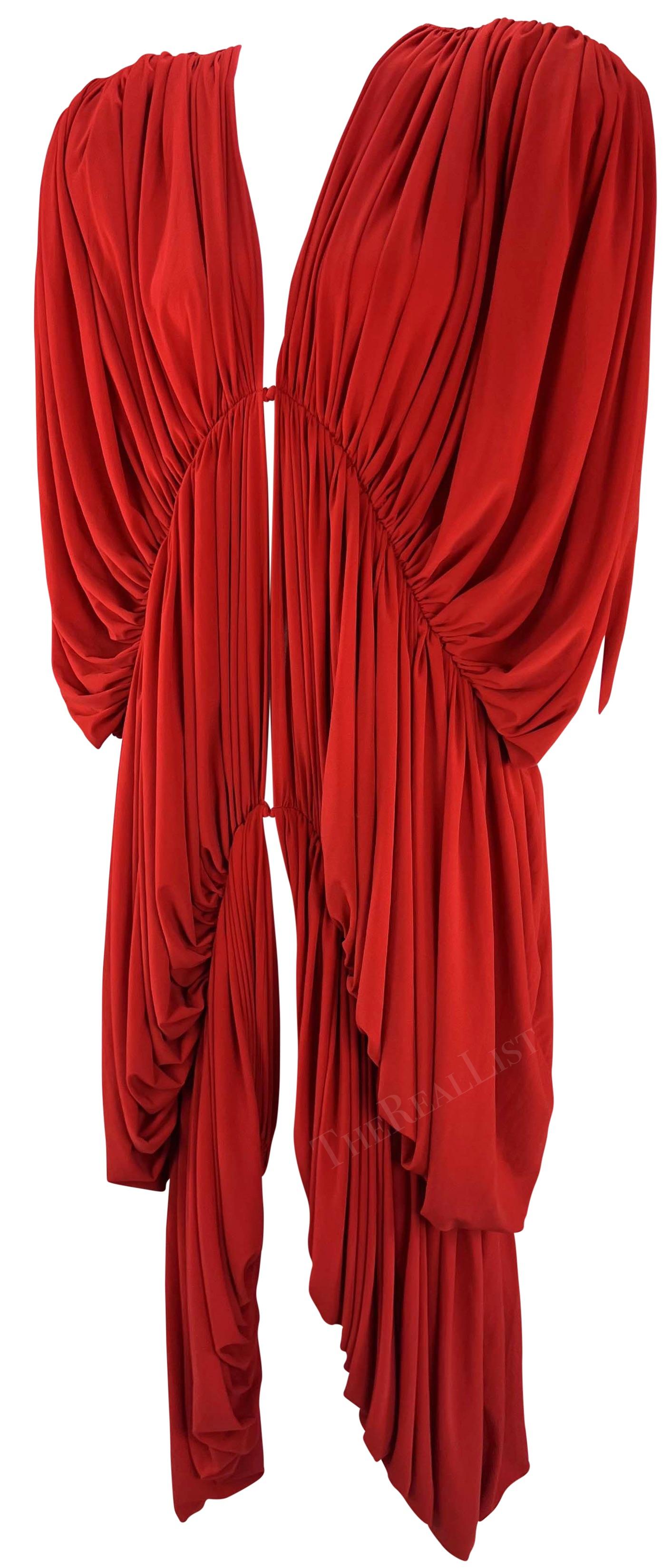 TheRealList presents: a bold red Norma Kamali parachute dress. From the early 1980s, this oversized dress features a plunging v-neckline, shoulder pads, and pleating throughout. This daring bright red dress features hook and eye closures down the