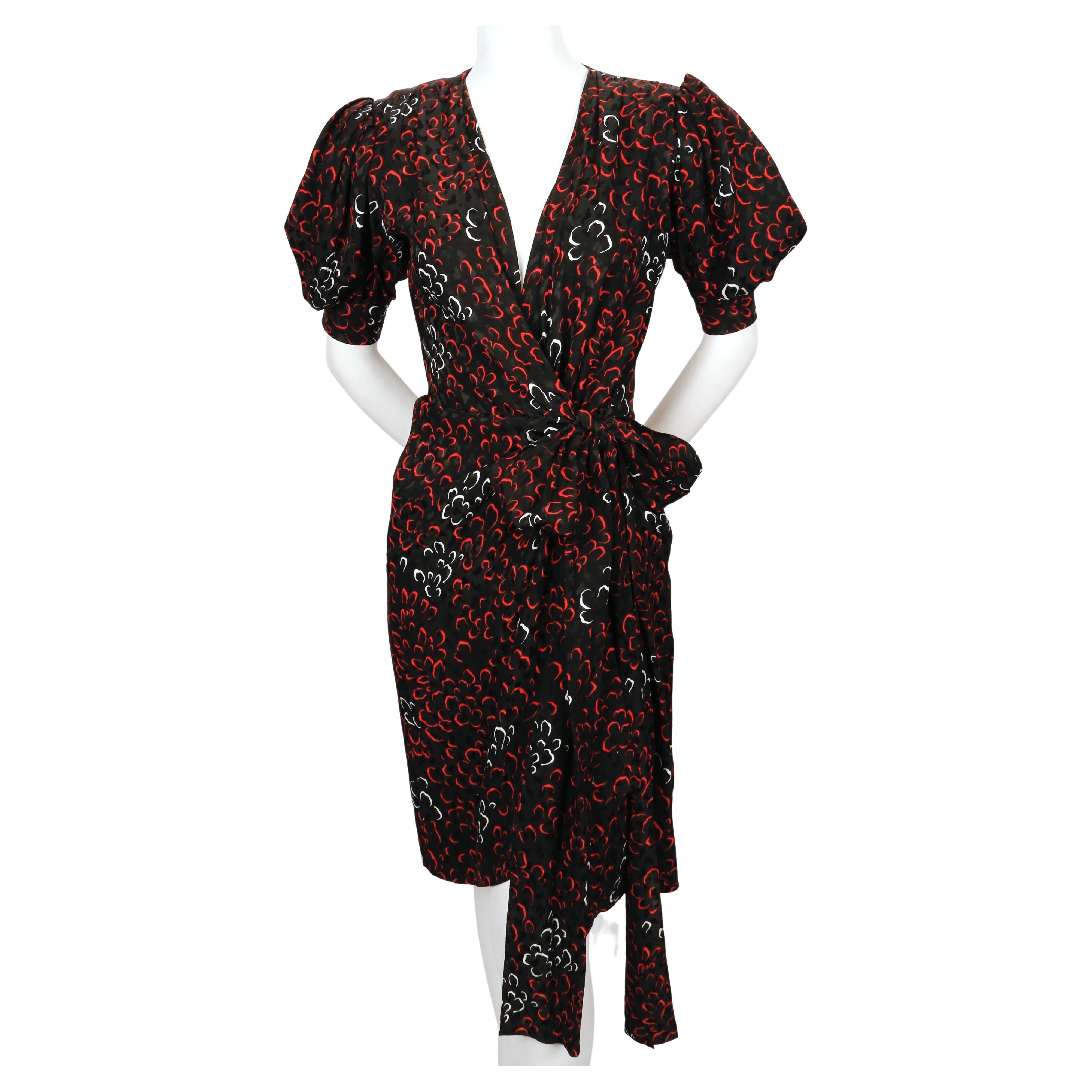 Abstract-printed, silk wrap dress from Yves Saint Laurent dating to the early 1980's. Colors are jet black, red and white. Labeled a French size 34. Approximate measurements: shoulder 14.25