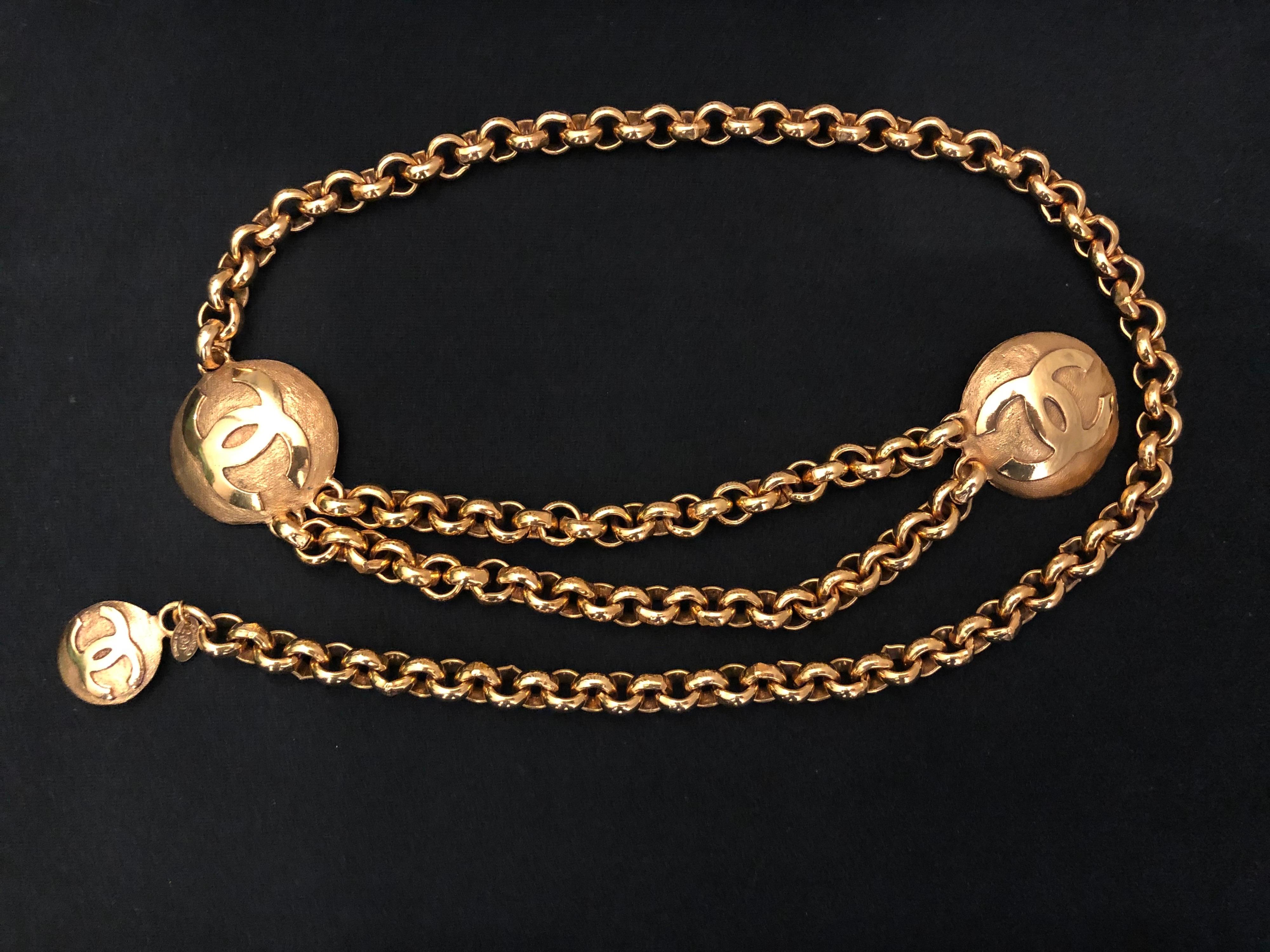 Early 1990s Chanel gold toned chain belt with double front chain featuring two large CC medallions and a small CC medallion charm. Measure 78.5 cm in wearable length medallions 4 cm and 2.3 cm in diameter. Stamped Chanel 29 made in France. Comes