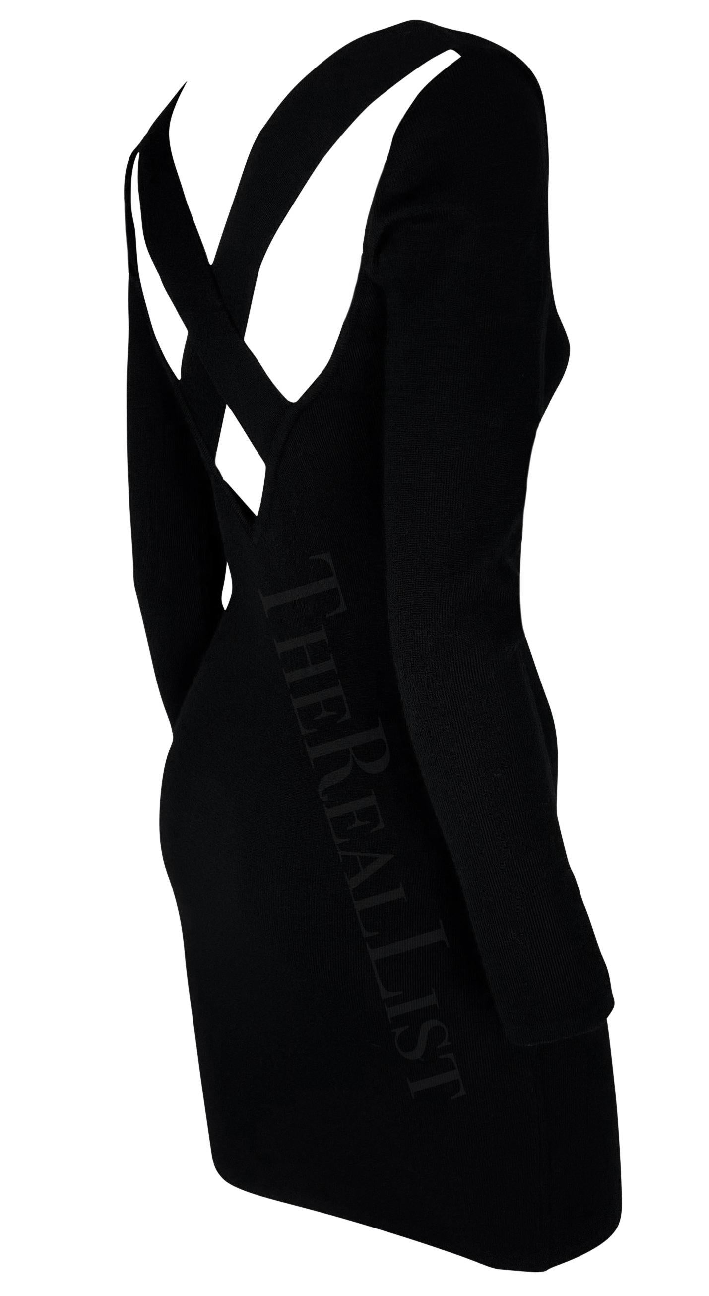 This black knit sweater dress by Dolce & Gabbana from the early 1990s features a sleek, form-fitting silhouette. Designed with a high neckline and long sleeves, the dress is elevated with a criss-cross strap detail over a semi-exposed back. Timeless