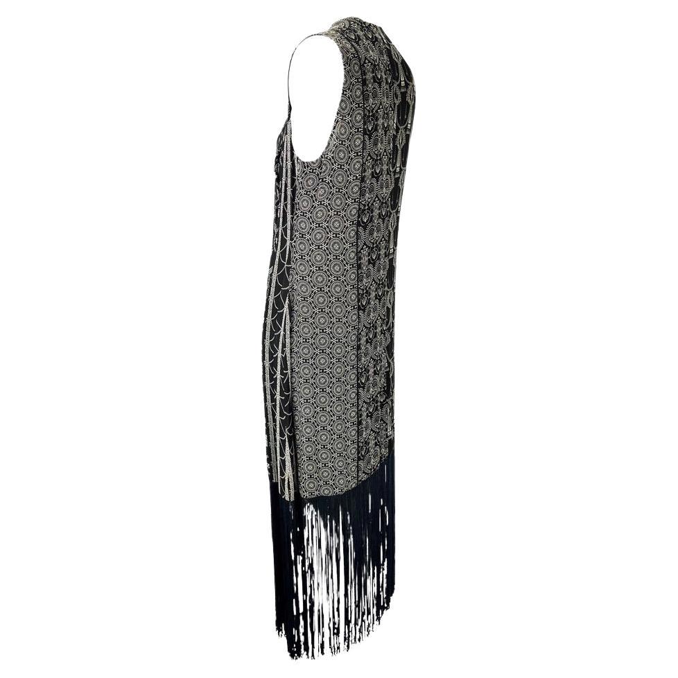 Presenting a vintage Dolce and Gabbana black and white fringe duster. From the 1990s, this lightweight tie vest features black and white monochrome Bohemian-inspired patterns as well as fringe at the hem. This beautiful piece is perfect for layering