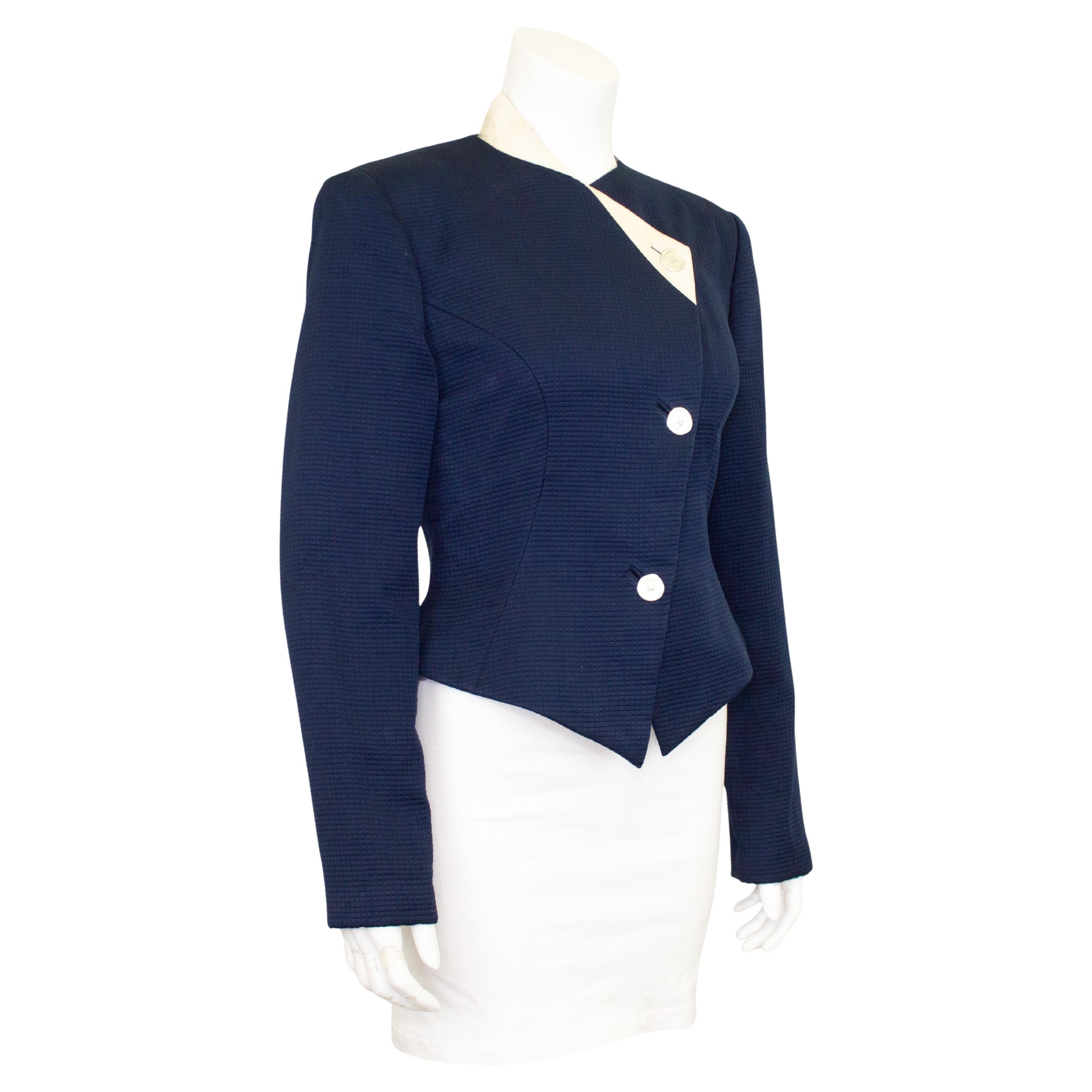 Lovely Geoffrey Beene jacket from the early 1990s. Navy blue silk pique with contrasting white ribbed silk asymmetric collar detail. The jacket is slightly cropped and fitted through the waist. Hammered flat silver metal buttons. Lined in navy blue