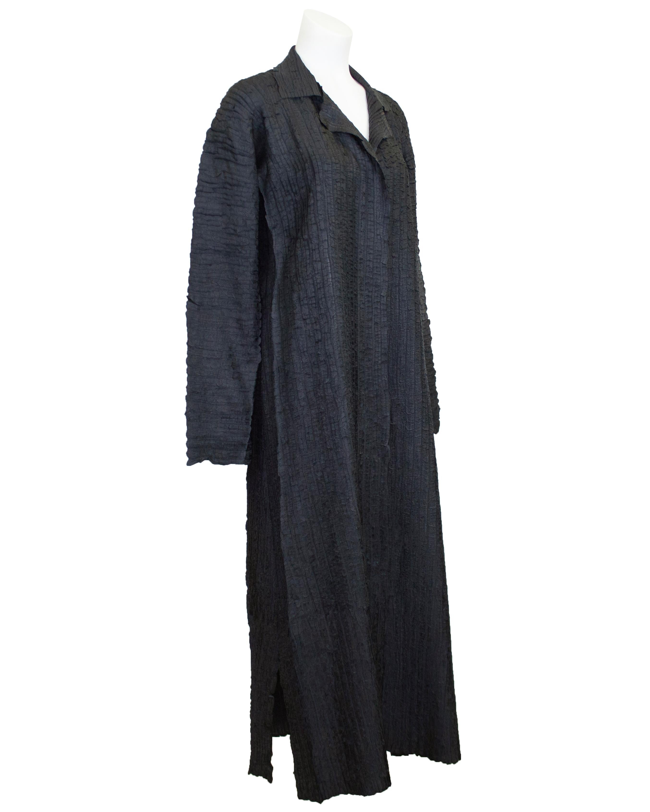 Spolverino/copricostume leggero grigio antracite Issey Miyake dei primi anni '90. La giacca ha una natura fluida ed è realizzata in un tessuto elasticizzato e increspato, tipico dei capi Fabrice. Da indossare aperto o con una cintura personalizzata,