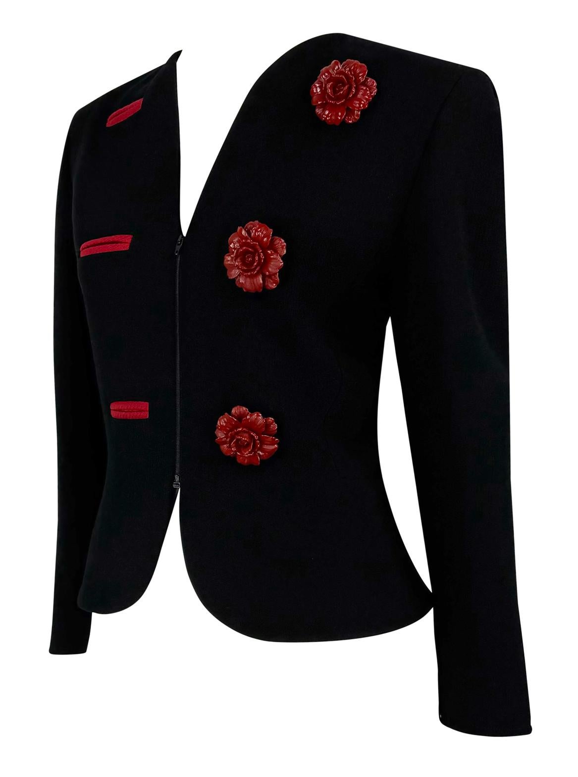This Valentino Garavani blazer from the early 1990s is crafted in black wool, showcasing a striking asymmetrical design. It features 3D red flower appliqués as faux button accents on one side, complemented by red slit details on the opposite.