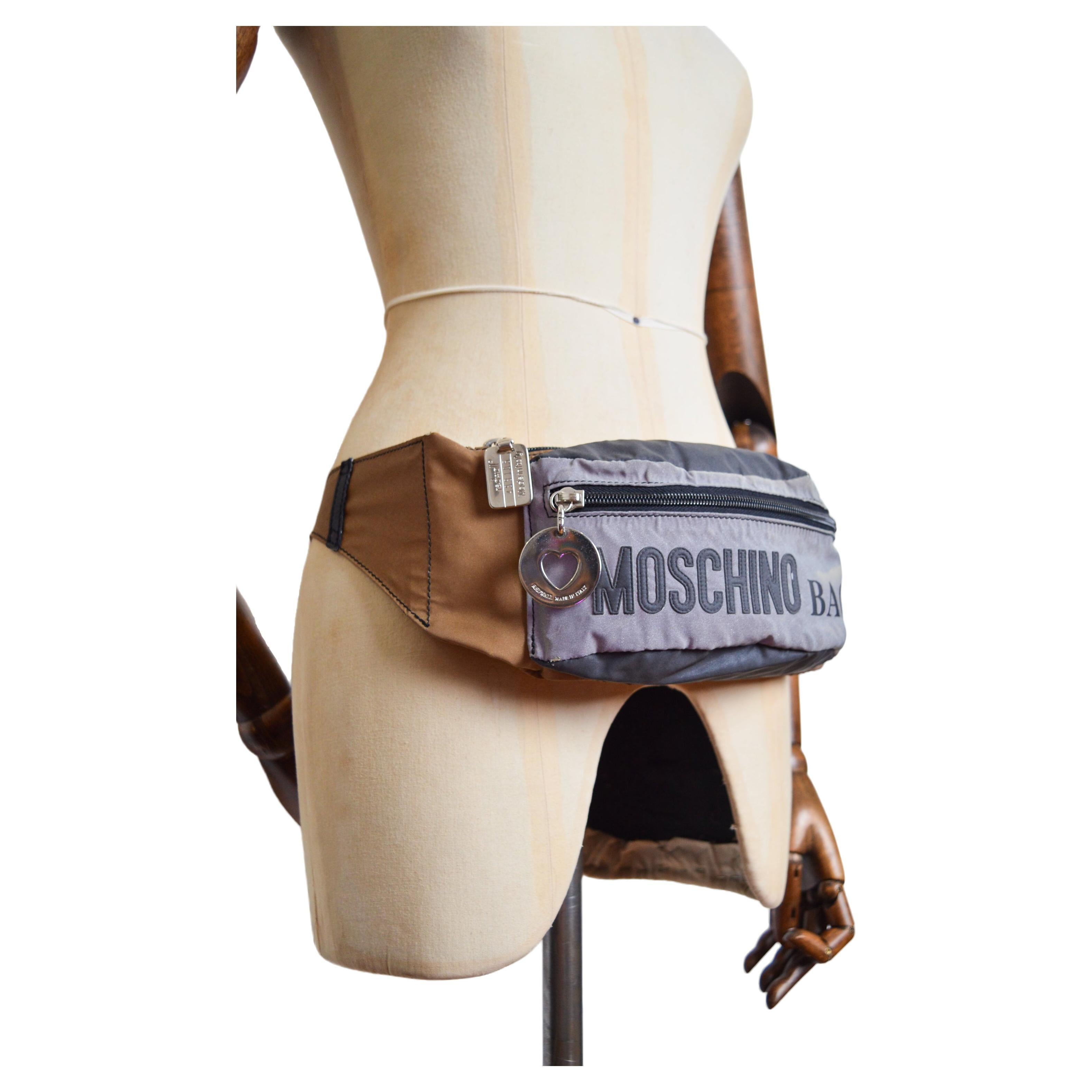 Vintage 1990's Moschino reflective Gold & Silver fanny pack / bum bag, with iconic & large 'MOSCHINO' lettering and silver metal hardware. 

An Iconic Vintage Piece !   

MADE IN ITALY   

Features: Large 'MOSCHINO' spellout letters, Single Zip