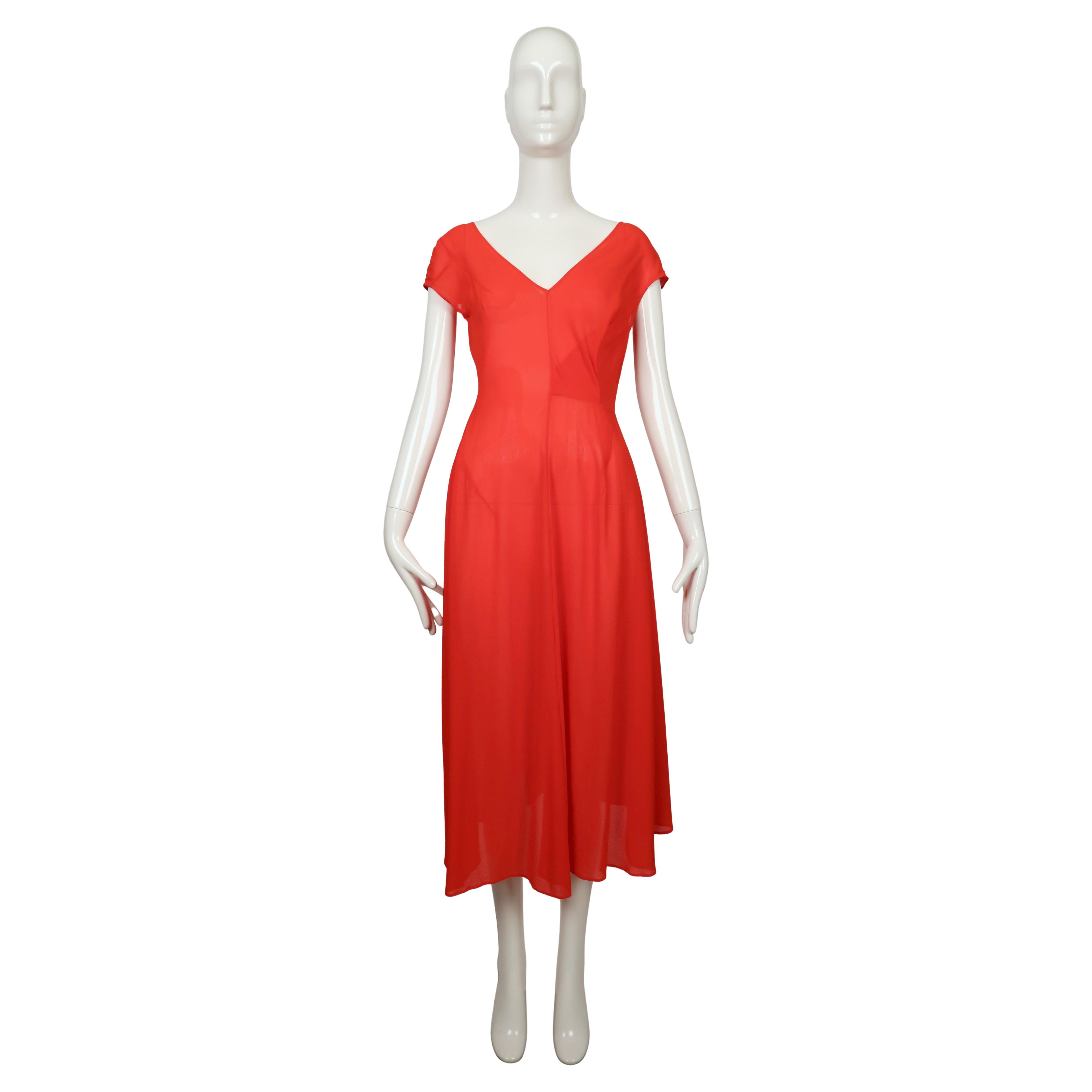 Cette phénoménale robe rouge conçue par Yohji Yamamoto et datant du début des années 1990 est réalisée en crêpe léger et légèrement semi-transparent. Ce modèle présente une large encolure en V flatteuse sur le devant et une légère échancrure dans le