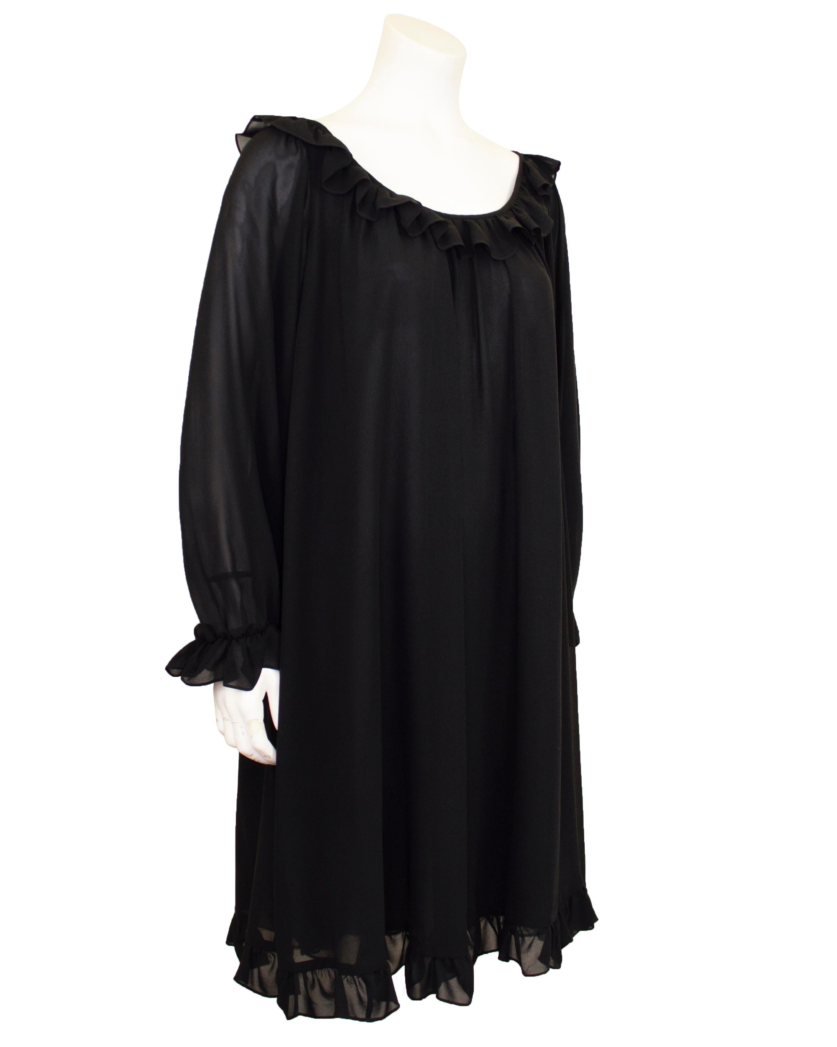 Early 1990s Yves Saint Laurent black chiffon babydoll dress. Long sleeve with a scoop neckline. Ruffle trim at the neckline, cuffs and hem. The body is lined, while the sleeves are sheer. Loose through the body and can fit sizes 4-10. Excellent
