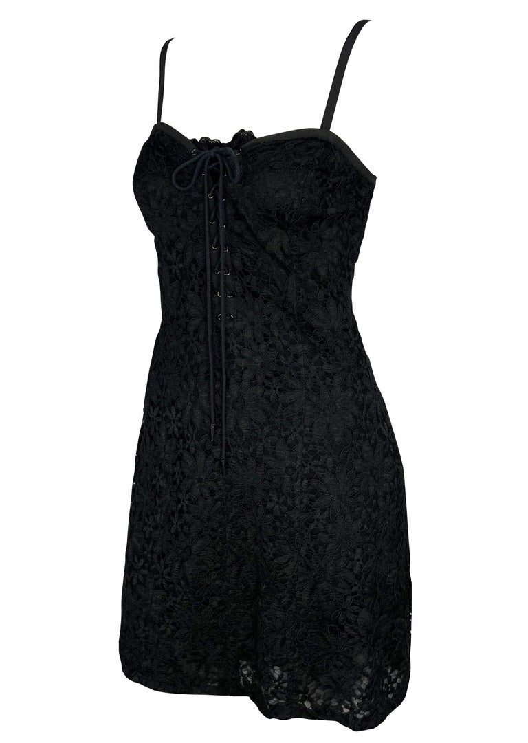 TheRealList presents: a black lace Yves Saint Laurent Rive Gauche mini dress. From the early 1990s, this beautiful dress is covered in lace and features a sweetheart-style neckline with spaghetti straps and a plunging lace-up detail at the front.
