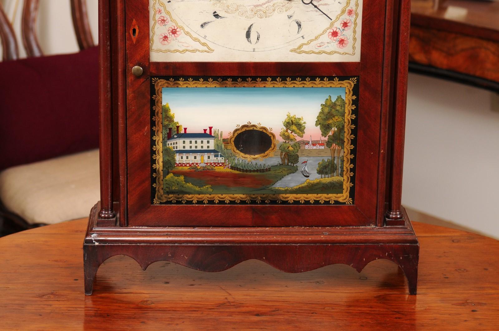 Acajou Horloge à colonne et à volutes en acajou avec paysage en églomisé, début du 19e C. en vente