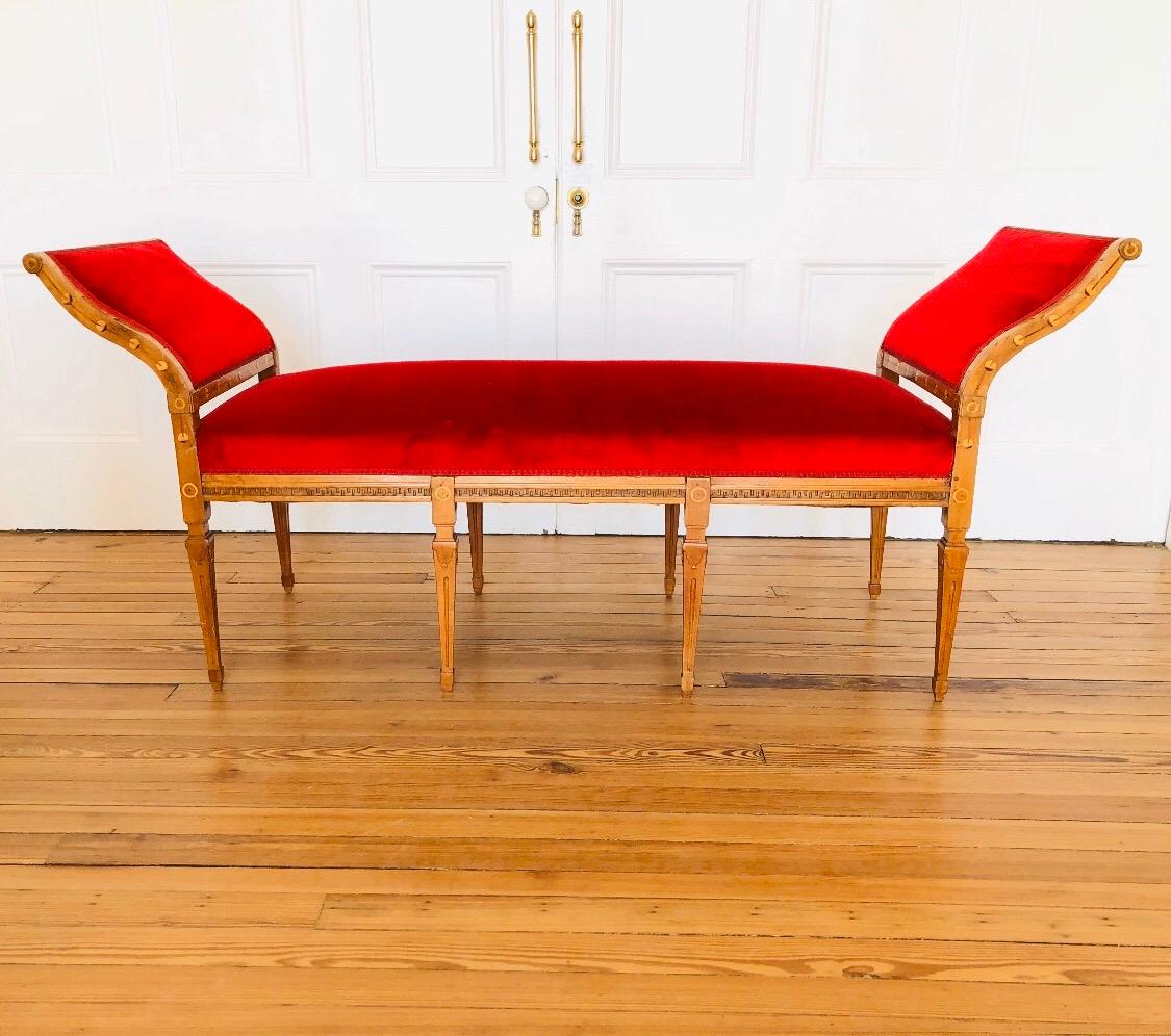 Questa panca Regal Biedermeier ha otto eleganti gambe affusolate intagliate, che sostengono una ringhiera intagliata a chiave greca, ed è rifinita con un bracciolo curvo abbinato. Il letto da giorno è in acero con intarsio di anelli e viti. Il letto