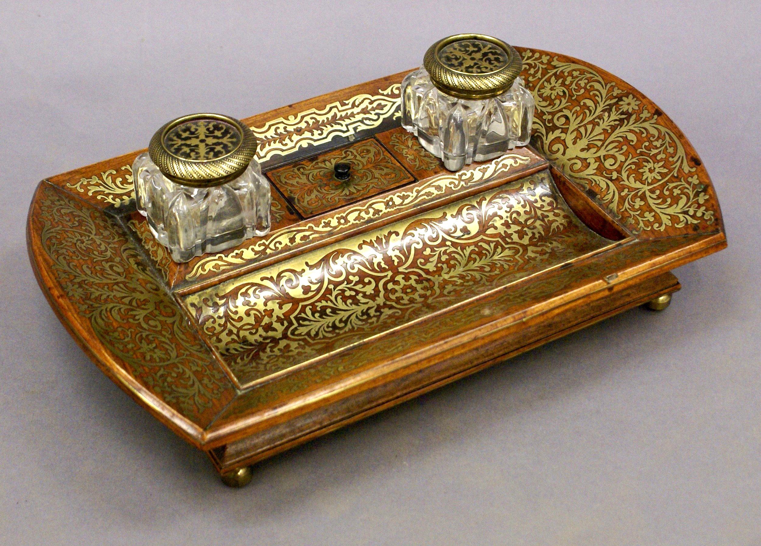 This superb and beautifully designed early 19th century inkstand is made of rosewood with an intricate brass inlay design. The stand is in excellent original condition taking into account its age and use, with the original bottles and a rich patina.