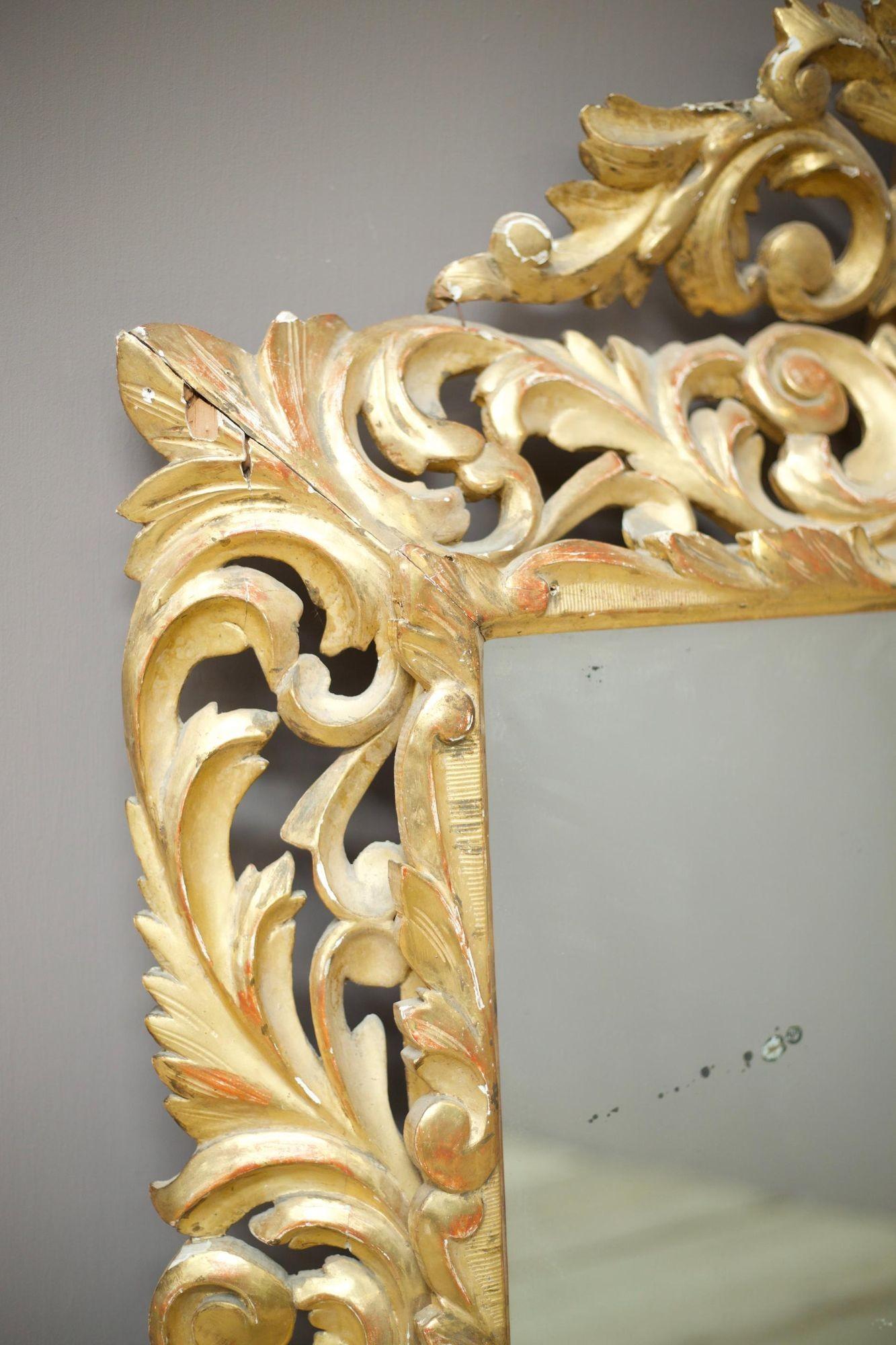 Il s'agit d'un exceptionnel miroir italien en bois doré du début du XIXe siècle, en très bon état général compte tenu de sa nature fragile. Ce miroir est d'une taille impressionnante et présente une plaque de miroir très propre avec de légères