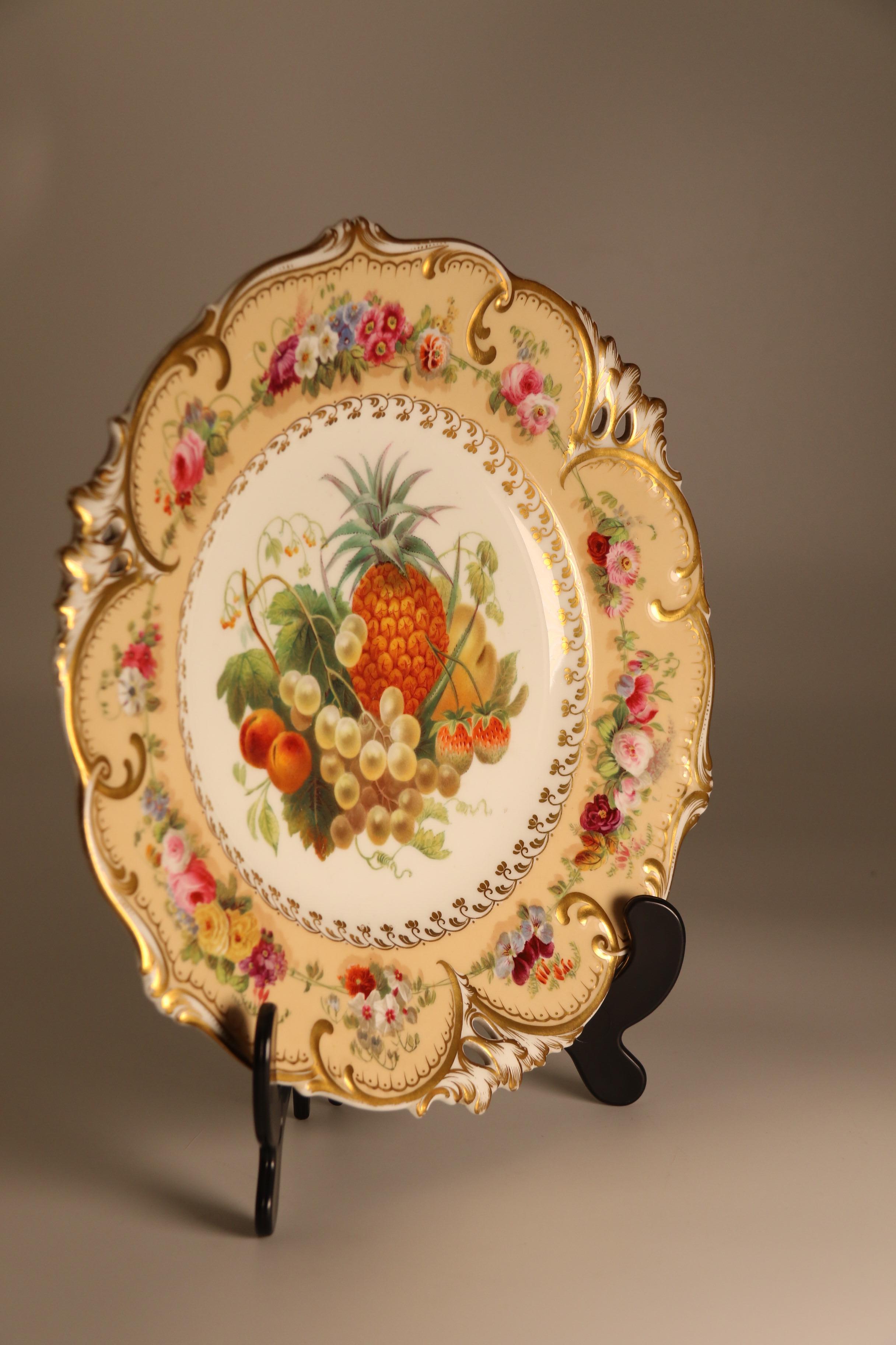 This superb early 19th century porcelain cabinet plate is very finely hand painted with a rich central display of exotic fruit and foliage over a white ground boardered with a delicate gilded floral pattern. The shaped and pierced surround has a