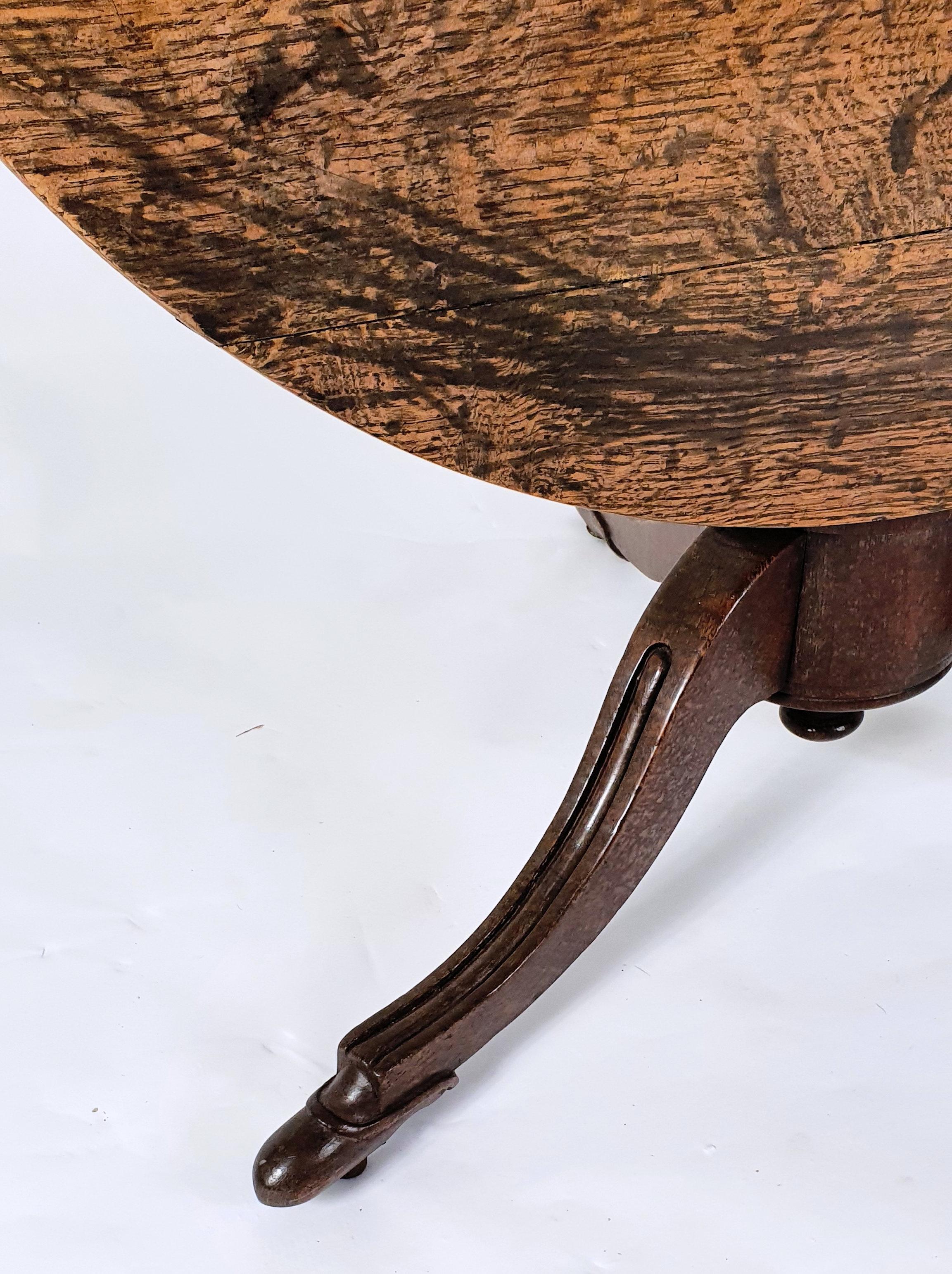 This beautiful and rare early 19th century country oak tilt top table breakfast table is possibly from the Isle of Man and stands on a central turned column with tripod supports ending on carved shoe feet. It measures 40 in – 101.6 cm in diameter