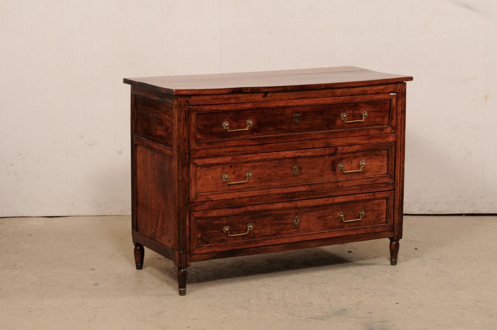 A French carved-wood chest of drawers from the early 19th century. This antique chest from France has a rectangular shaped top which slightly overhangs the case beneath which houses three dovetailed and graduated, recessed panel drawers, fitted with