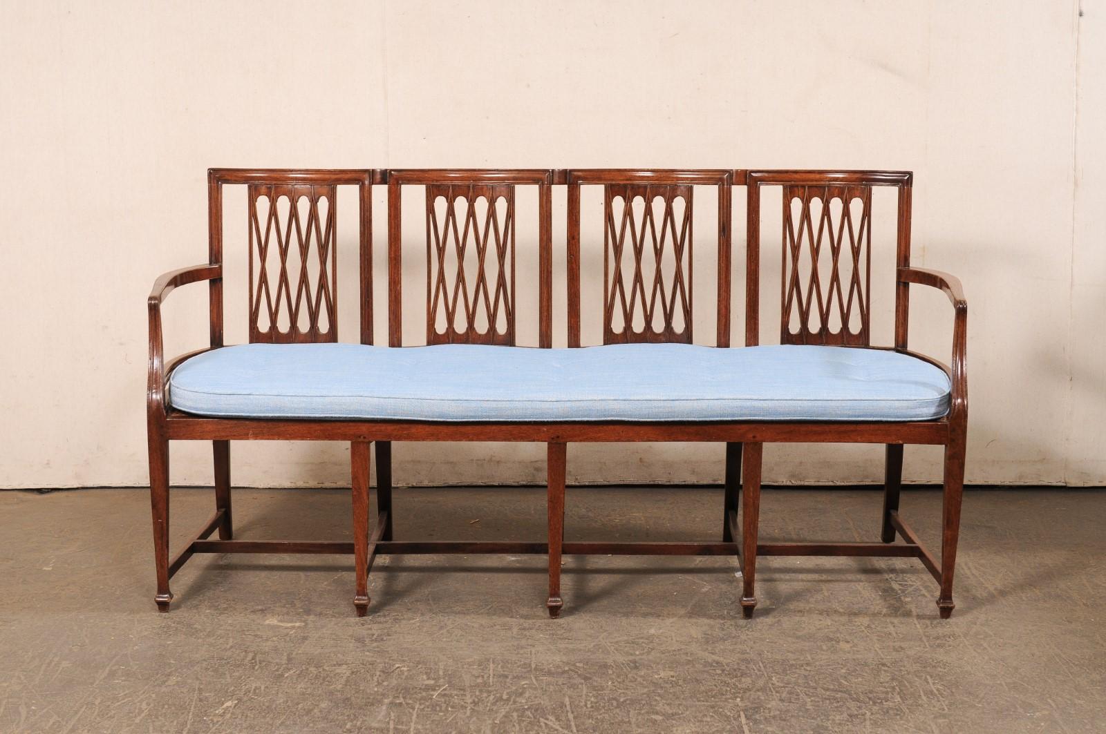 Banquette italienne en bois sculpté, à dossier de quatre chaises et assise en rotin, du début du XIXe siècle. Ce banc ancien d'Italie présente un dossier à quatre chaises, avec d'élégantes cannelures en treillis à l'intérieur d'un cadre