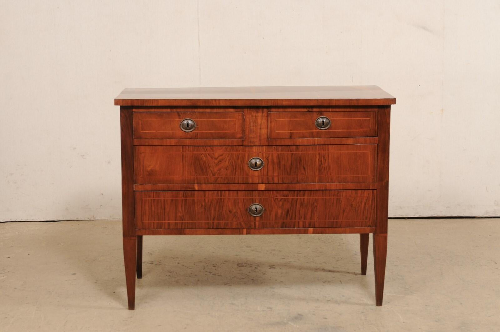 An Italian chest of four drawers from the early 19th century. This antique chest from Italy has been designed in nice clean lines, allowing the beautifully veneered wood grain and inlay banding to speak for the simple elegance of this piece. The