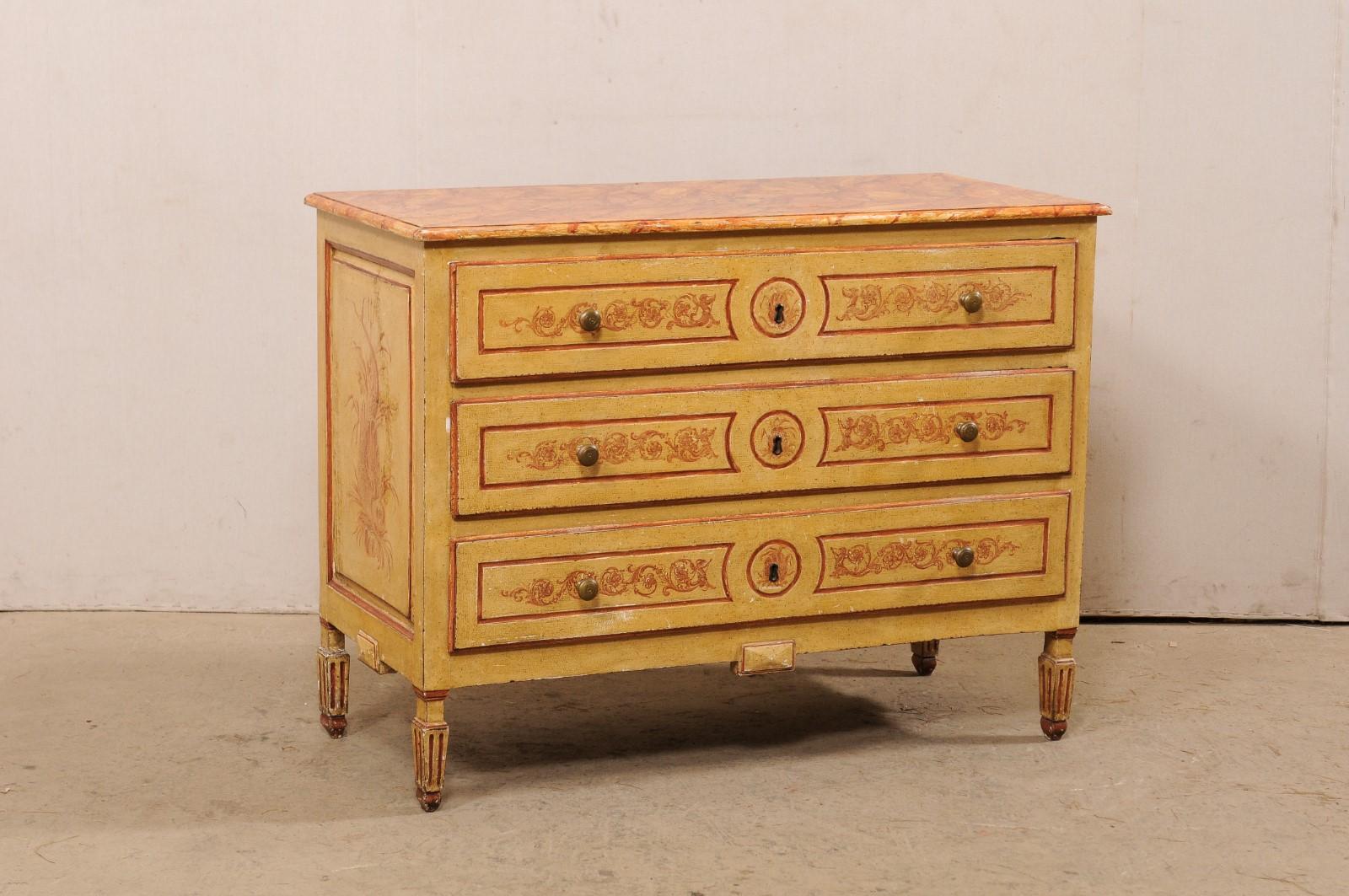 An Italian three-drawer chest, with its original artistic hand-painted finish, from the early 19th century. This antique commode from Italy has its original artisan painted finish which includes a faux-marbled top, drawer fronts outlining the panel