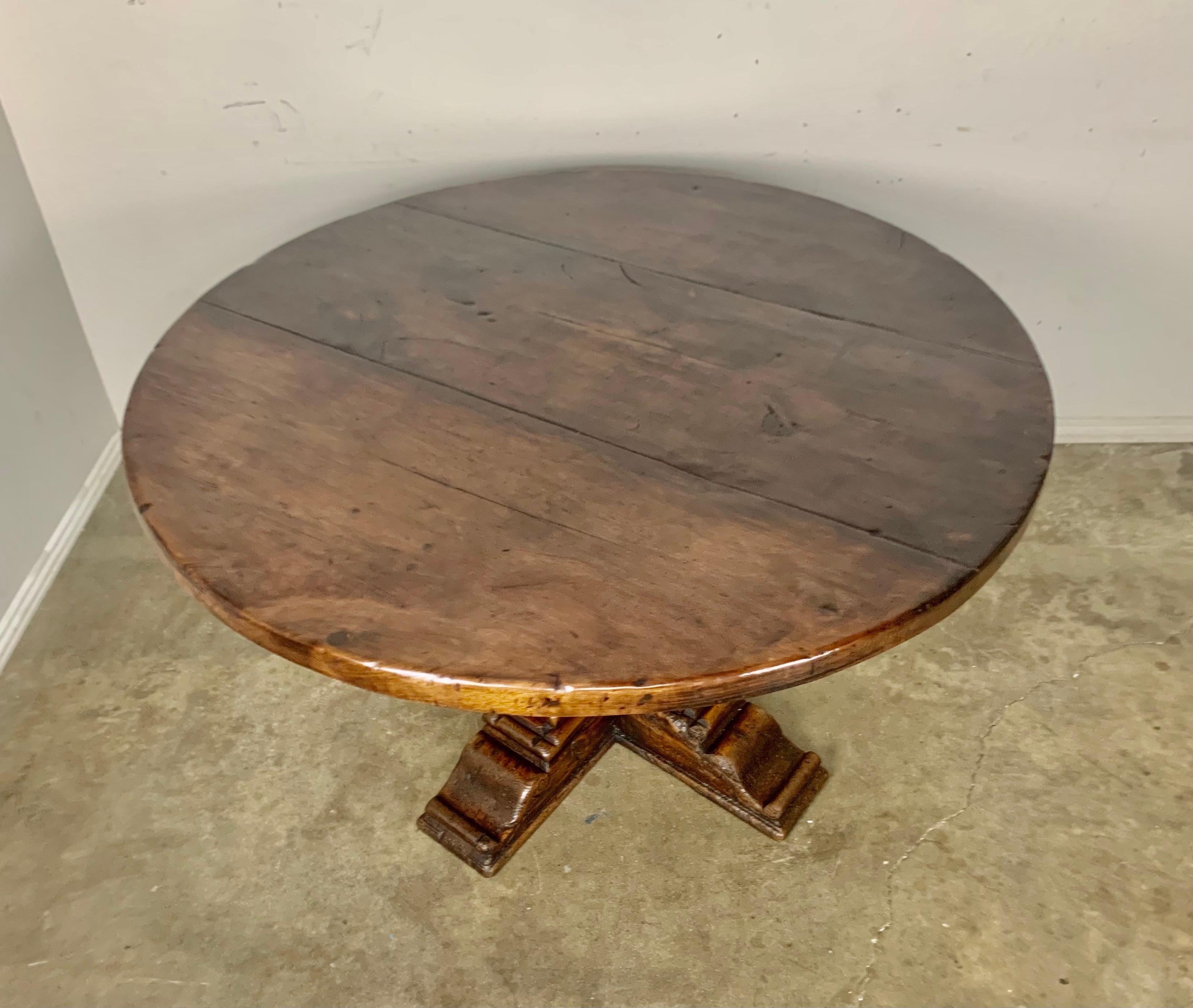 19th C. Walnut Italian round shaped pedestal dining table. The solid round top sits on a pedestal made up of four columns resting on a solid base. The patina is beautiful and the simple shape lends itself to many styles of decor.