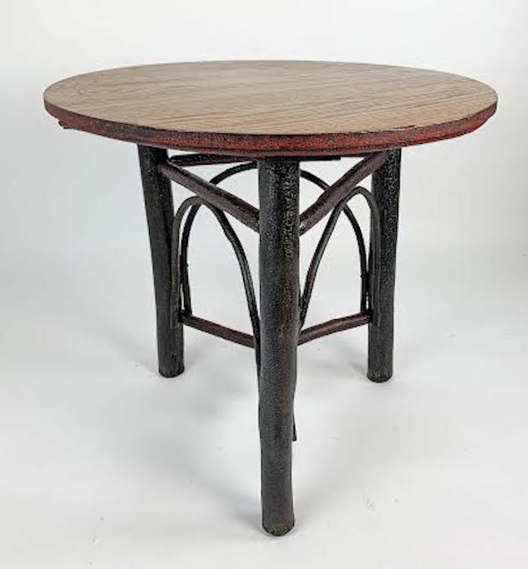 Early 19th C Old Hickory lamp table dated/ signed 1910 Old Hickory Chair Company. It has a tripod base with a combination of arched and triangular stretchers.
It has an interesting multi-layer history of finishes - there are vestiges of crazed old