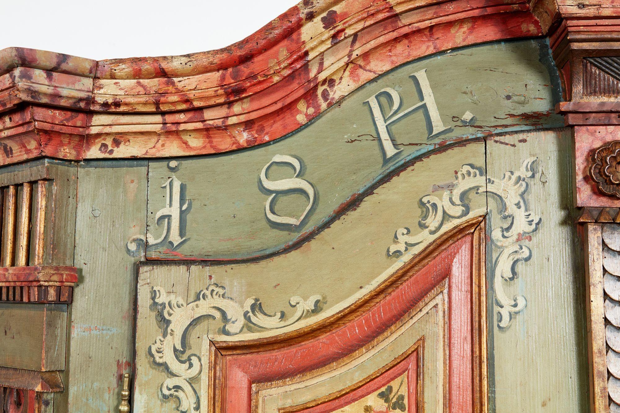 Très bon meuble ou armoire bavaroise du début du 19e siècle en finition peinte d'origine, y compris la rocaille, le faux marbre et la peinture au grain, le cimier arqué surmontant les initiales et la date 