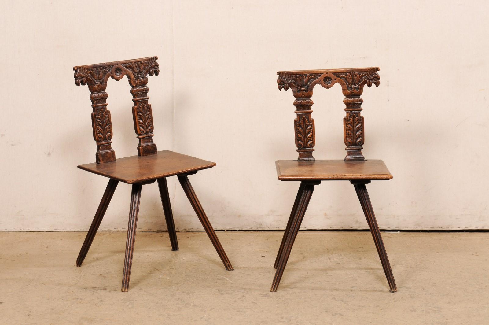 Ein europäisches Paar geschnitzter Holzstühle aus dem 19. Jahrhundert. Dieses antike Stuhlpaar aus Europa verfügt über eine stark verzierte Rückenlehne mit Reliefschnitzereien, die ein Paar verschnörkelte Säulen mit einem Blattmotiv und einem