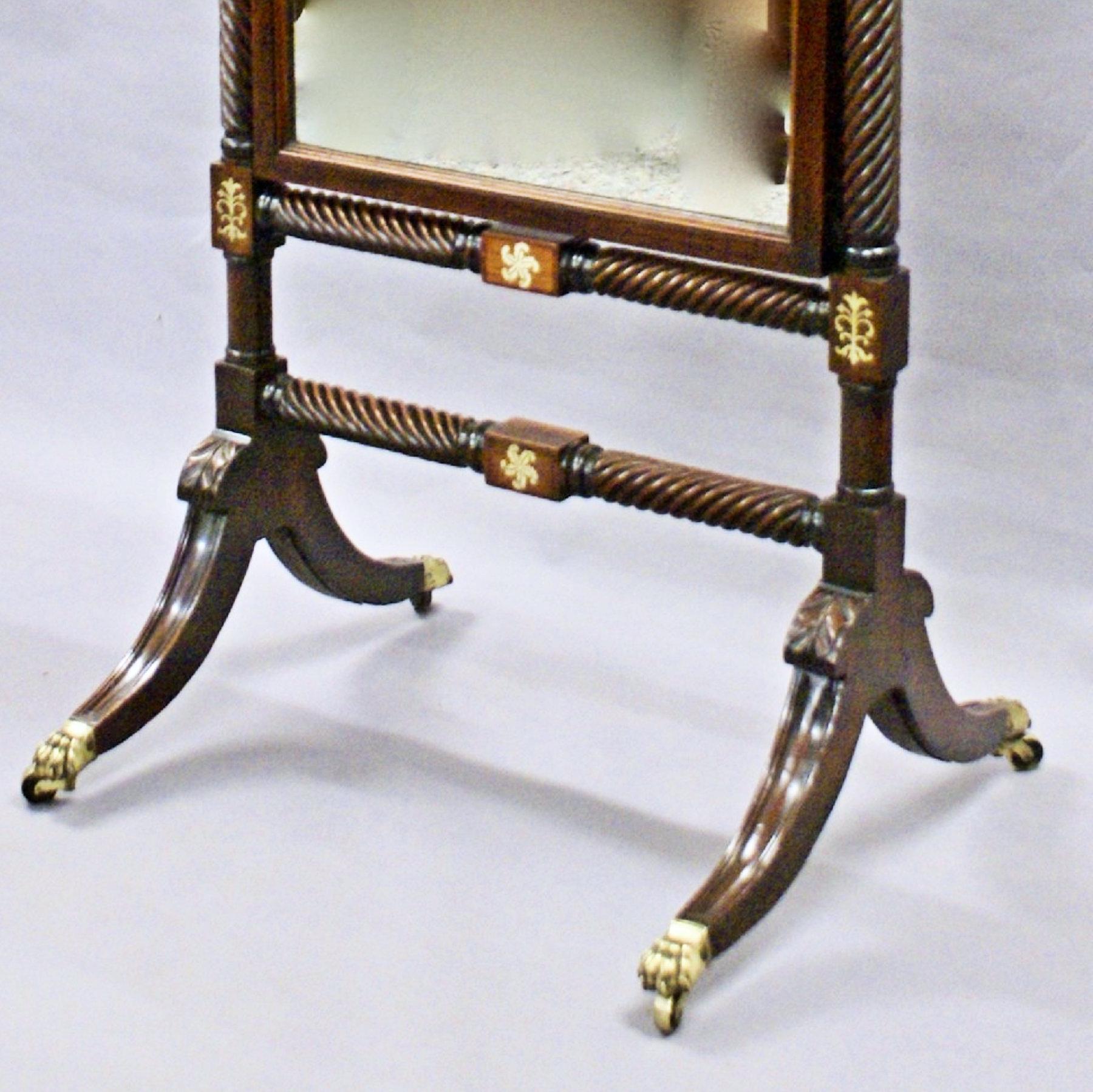 This beautiful and stylish fine quality early 19th century rosewood cheval mirror features lovely brass inlay with brass floral decor and the original mirror supported on raised sabre legs, carved knees and brass claw castors. The mercury plate