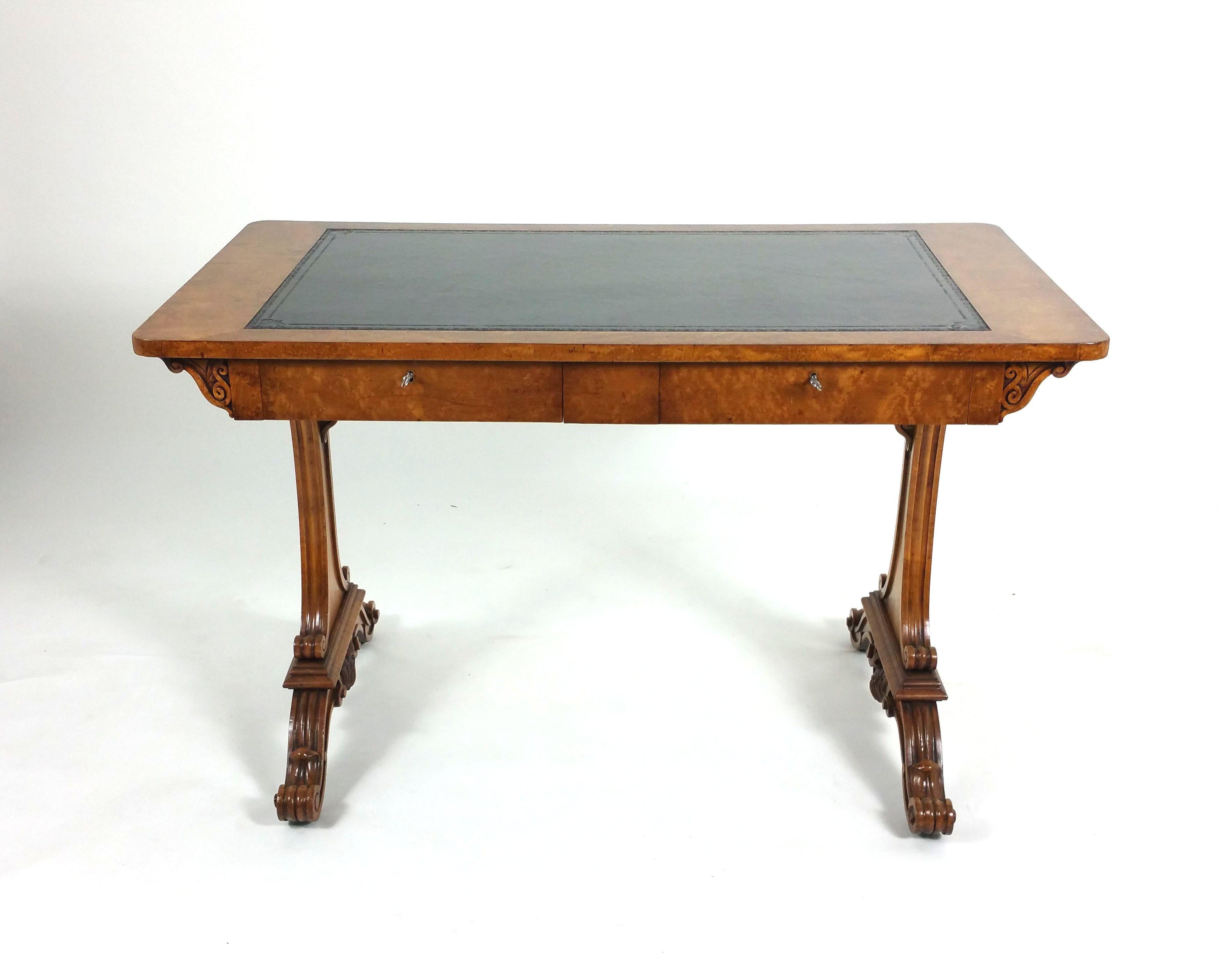 This very good looking and well-proportioned early 19th century. satin birch library table features 2 drawers on one side with 2 matching faux drawers on the other, with well carved supports and a black leather tooled writing surface. It measures 45