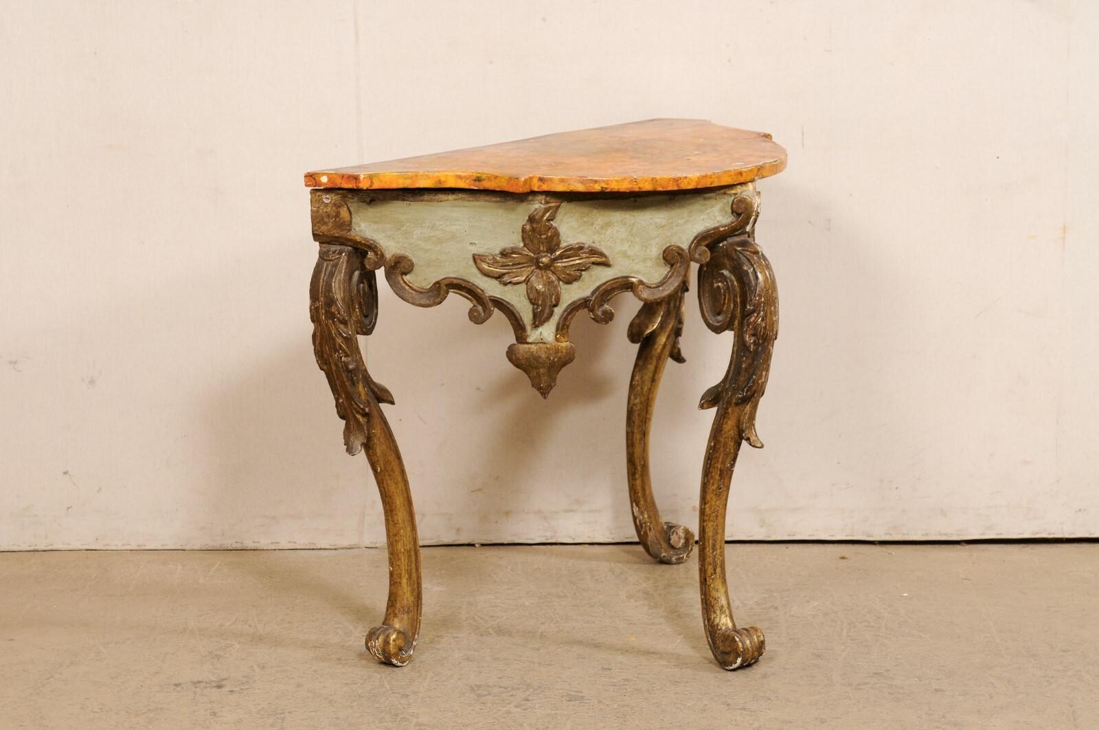A unique Spanish carved and painted wood console table from the early 19th century (possibly older). This antique Baroque style console table from Spain has a curvaceous design with a faux-marble top that is outwardly scalloped at front, convex