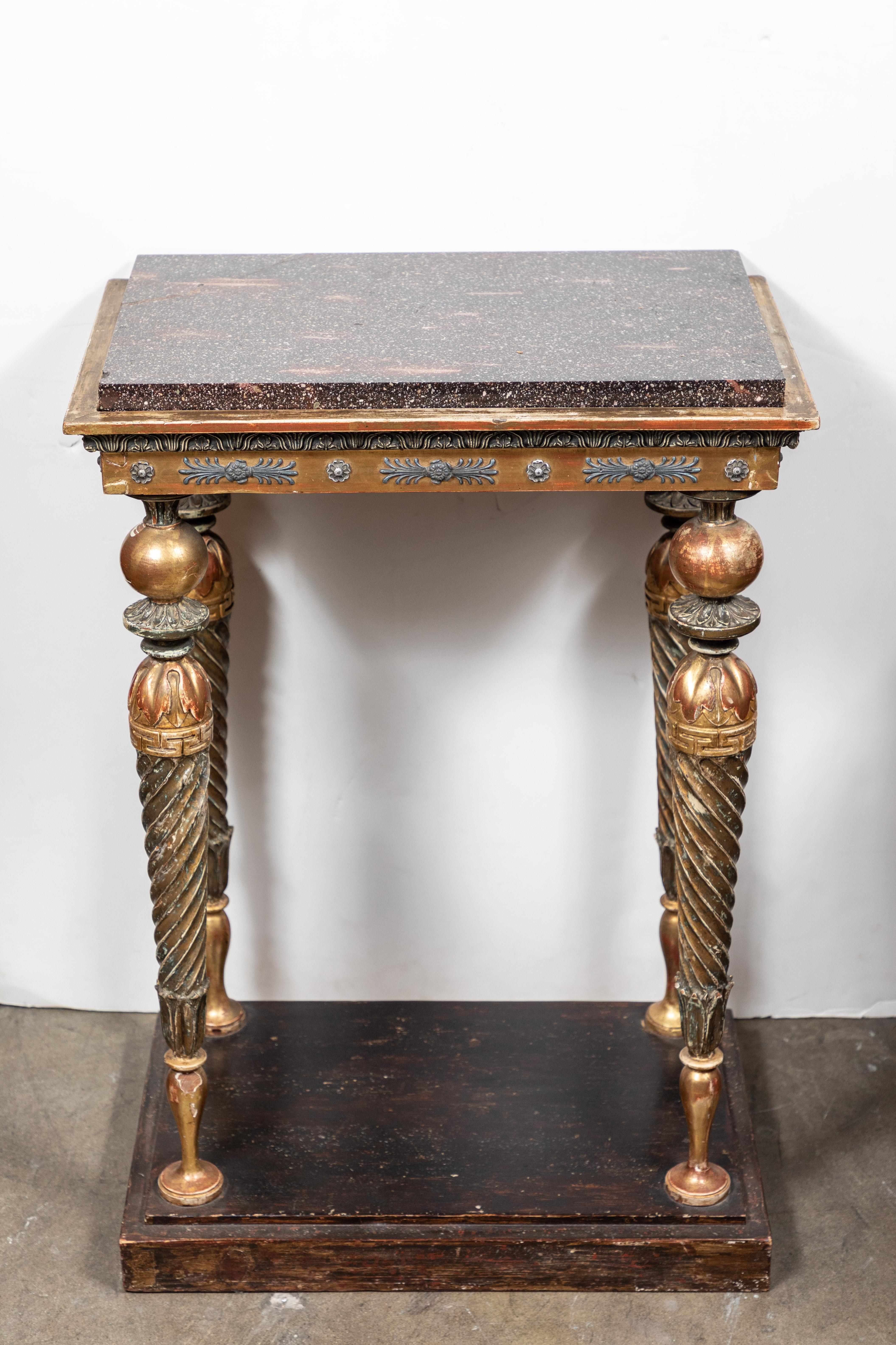Magnifique table console à trois côtés, sculptée, peinte et dorée à la main, avec des pieds fuselés en spirale surmontés d'un tablier en relief et d'un plateau en porphyre d'origine.