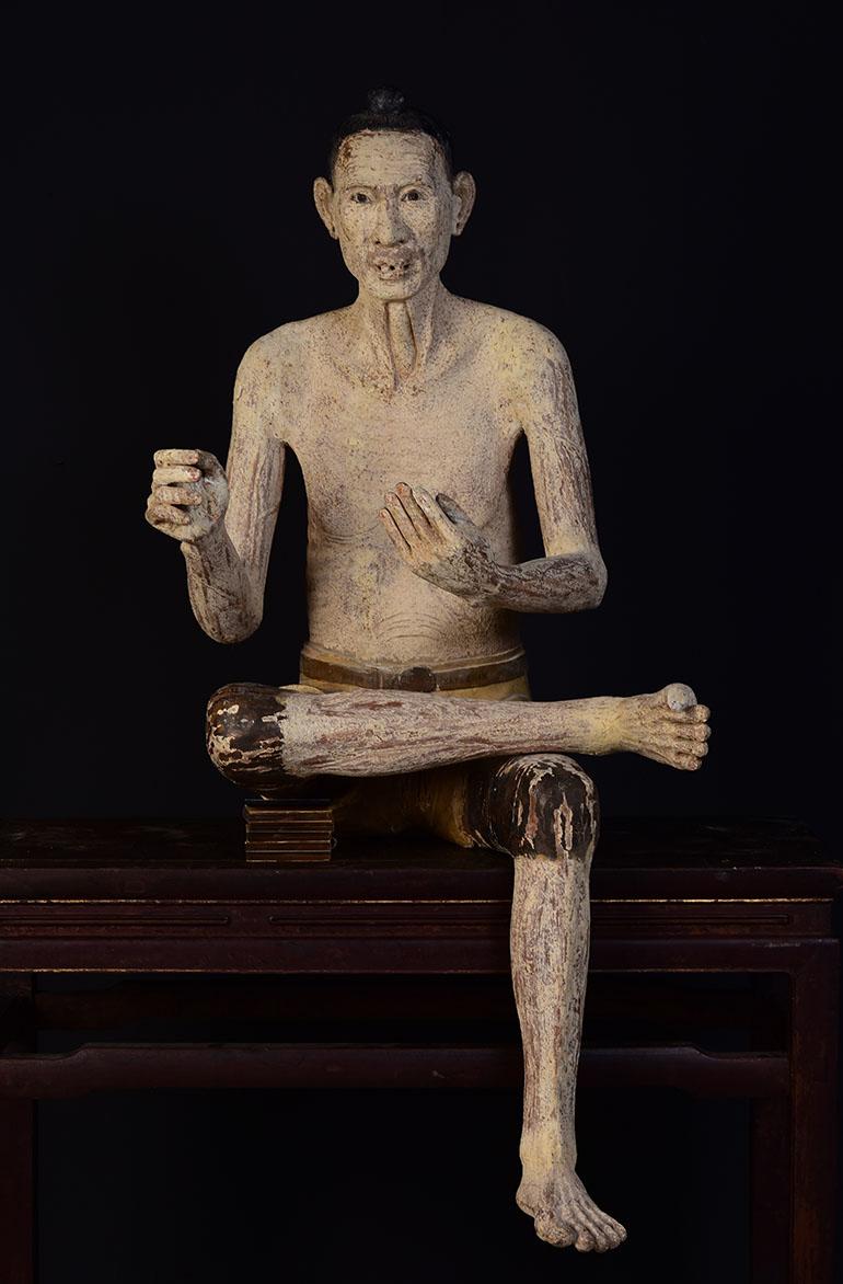 Very rare and large Burmese wooden sculpture of old man.

Age: Burma, Early Mandalay Period, Early 19th Century
Size: Height 135.5 C.M. / Width 62 C.M. / Depth 72 C.M.
Condition: Nice condition overall (some expected degradation due to its