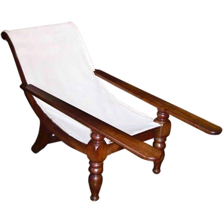 This West Indies solid mahogany planter's chair was made in the early 19th century in Martinique, circa 1820, in the British Colonial style and features the classical extending arms. A similar chair can be found in the book 